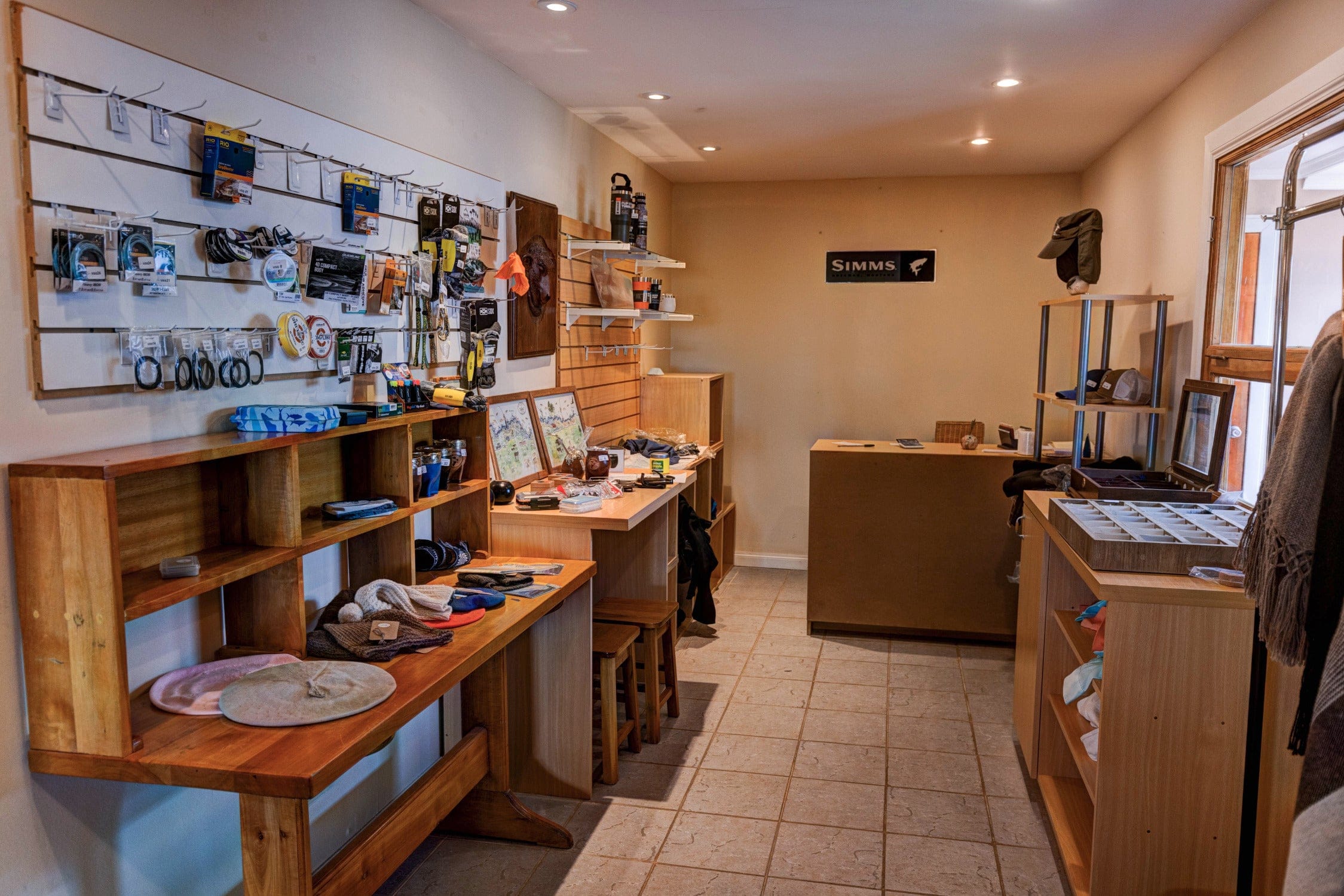 Cozy lodge shop interior with wooden shelves, beige walls, hats and outdoor gear for a mountain trip