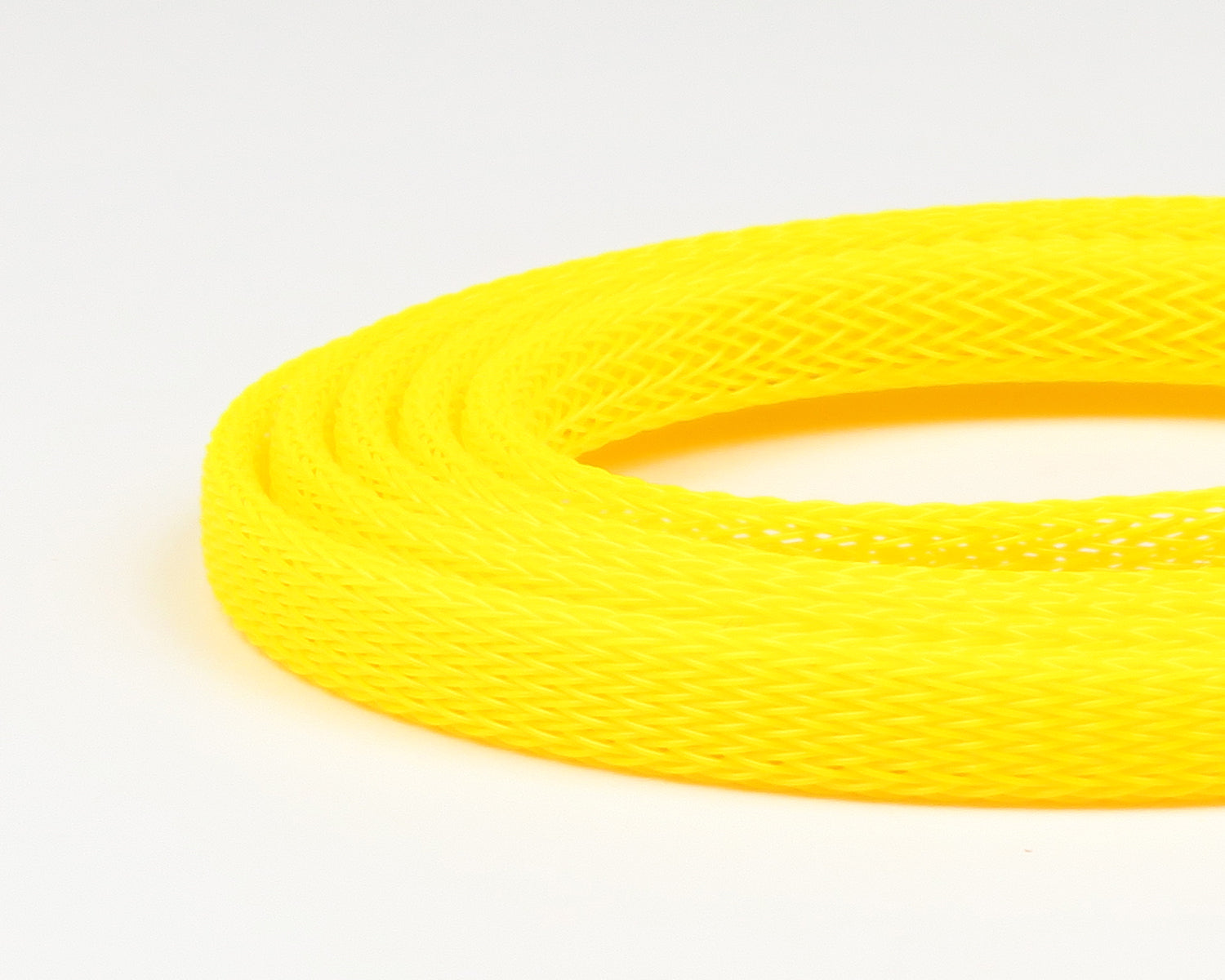 Fluorescent yellow braided plastic body tubing coiled, open mesh texture for fly tying