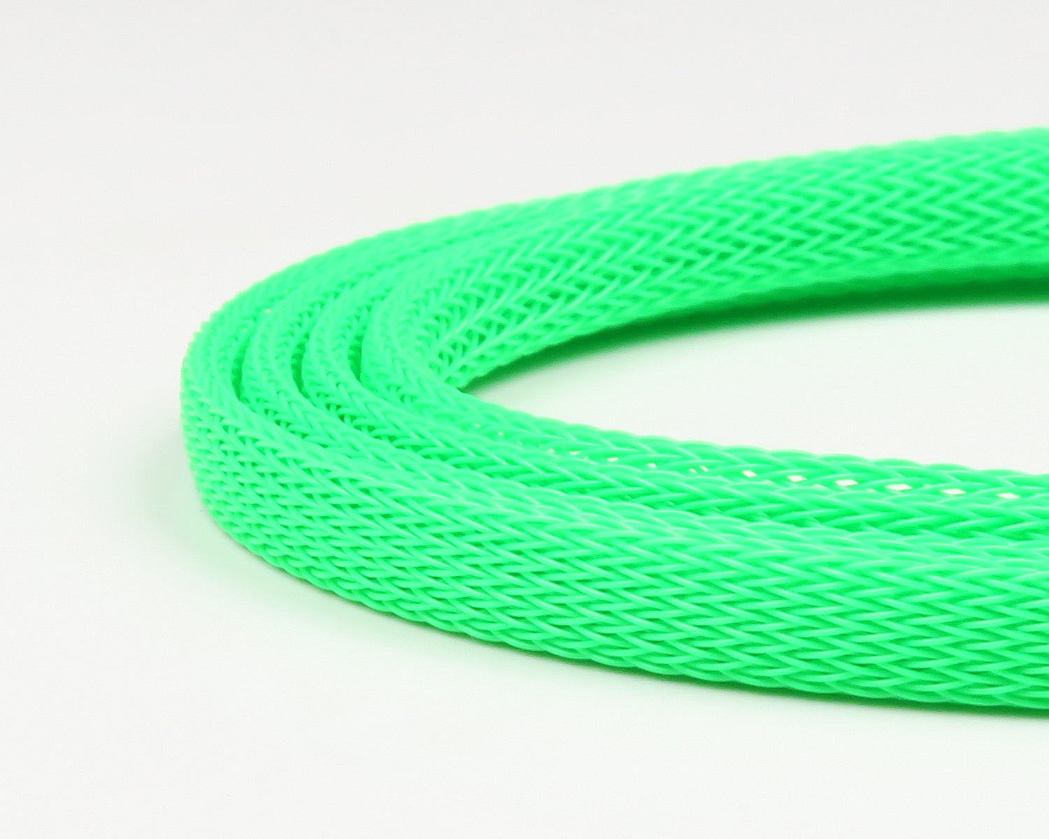 Neon green braided plastic body tubing for fly tying with woven mesh texture, flexible tubular material