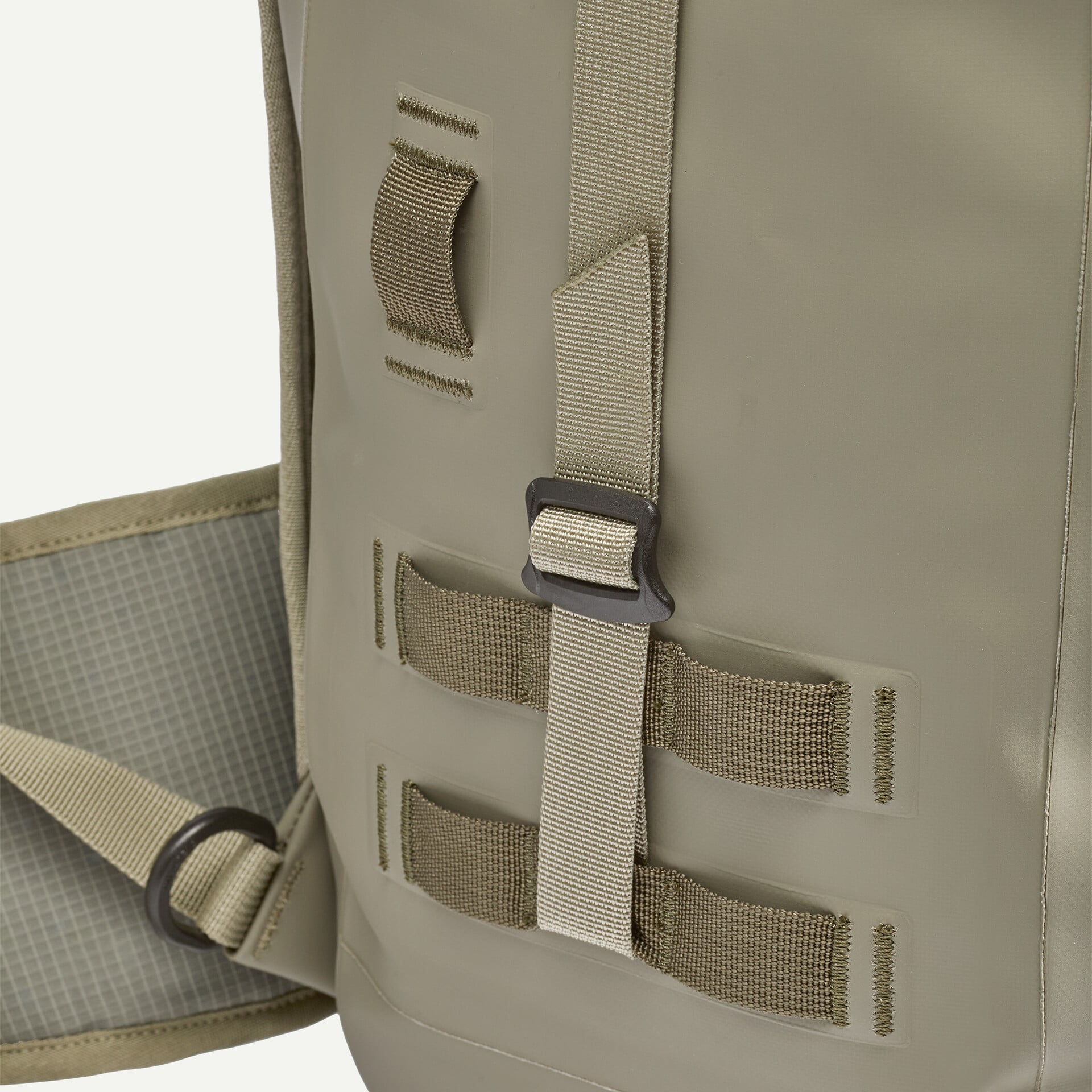Khaki Patagonia roll-top pack detail showing coated waterproof fabric, tan webbing straps and D-ring