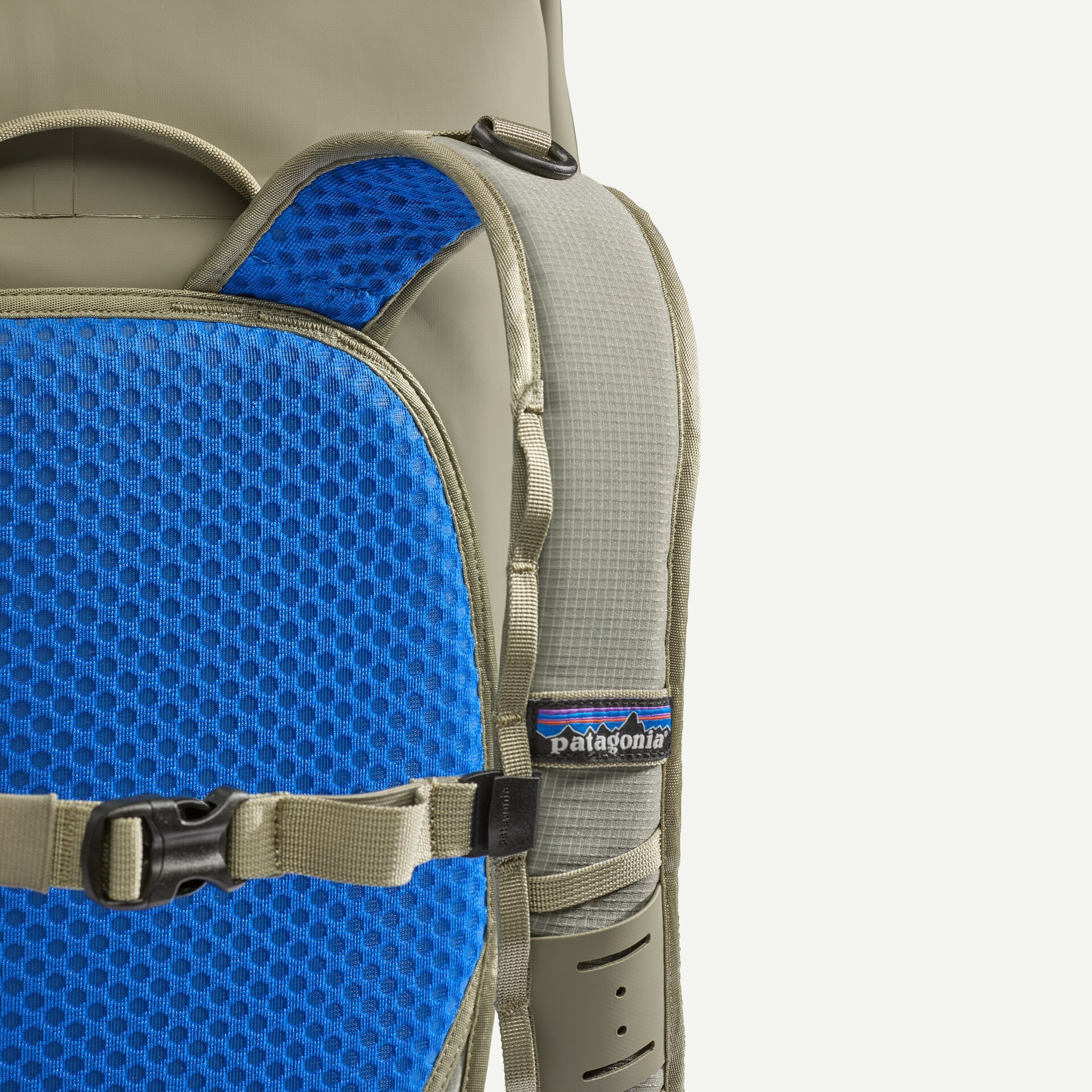Olive Patagonia Guidewater roll-top pack close-up showing khaki strap, blue padded mesh back panel and sternum buckle