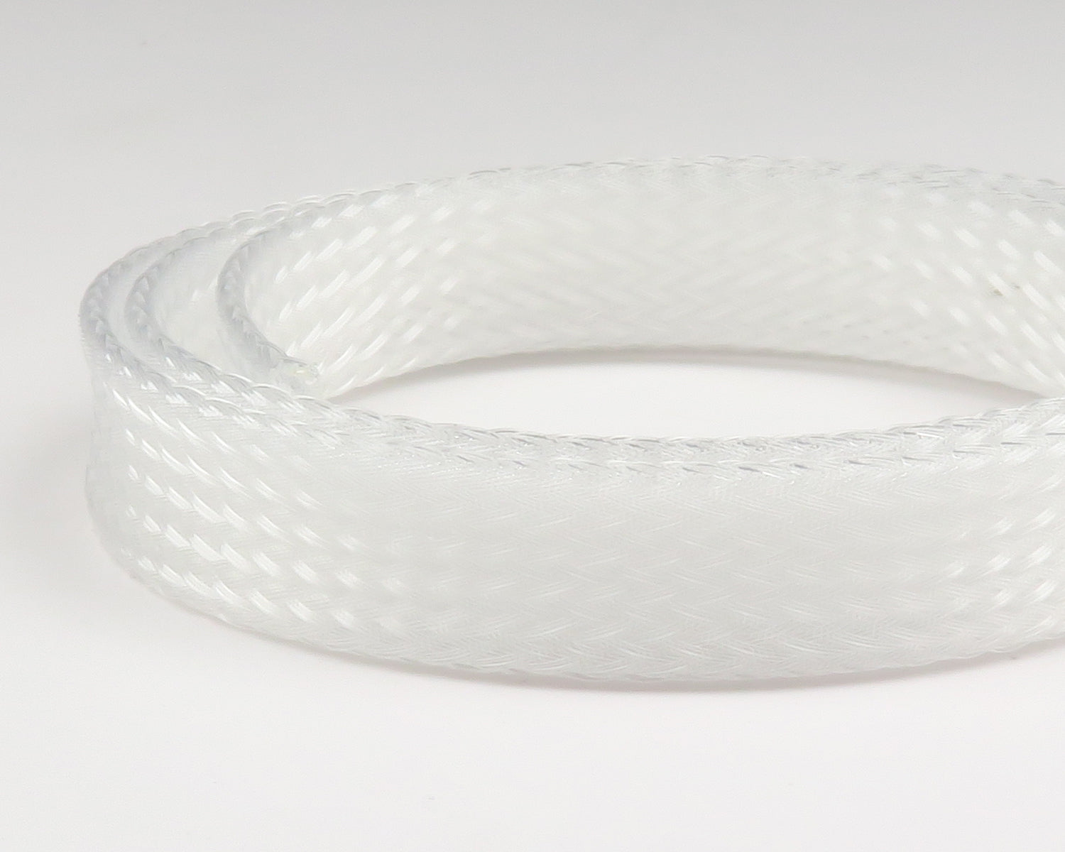 White translucent braided nylon body tubing coil with woven texture for fly tying
