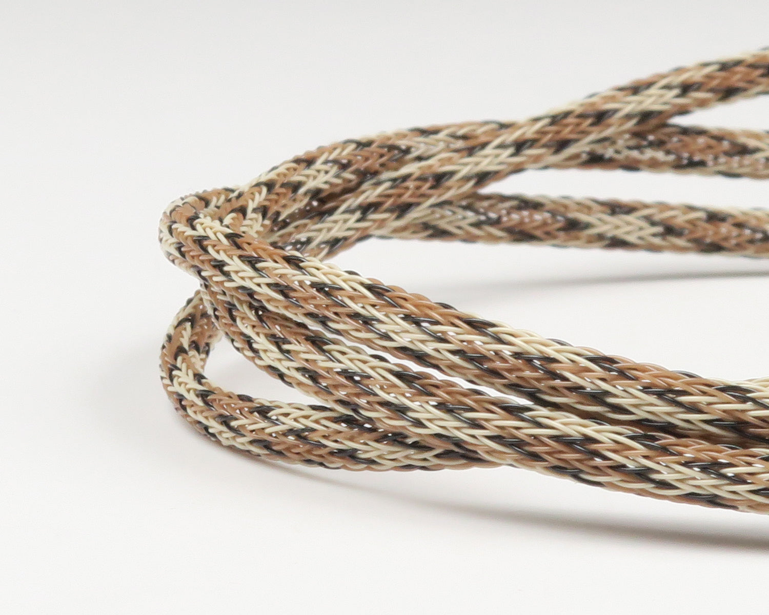 Coiled braided Fish-Skull body tubing in tan, brown, cream and black, synthetic woven fly tying tubing