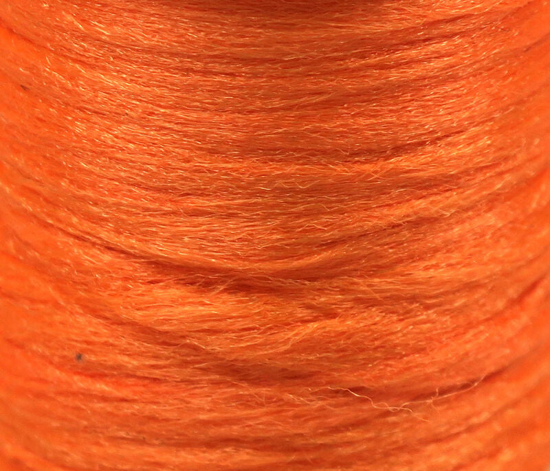 Bright orange Hareline Antron yarn spool close-up showing fuzzy synthetic fibers for fly tying