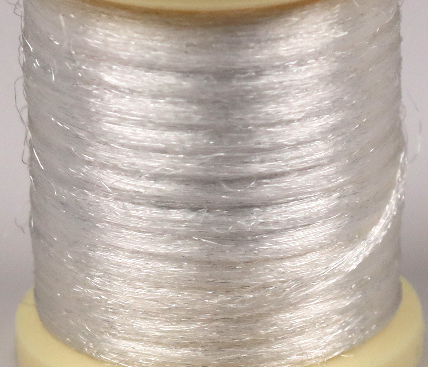 Pearl white Hareline Antron yarn on spool, shiny translucent synthetic fibers for fly tying