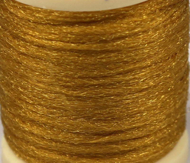Golden Hareline Antron yarn spool with shimmering synthetic fibers for fly tying, fine textured metallic gold strands