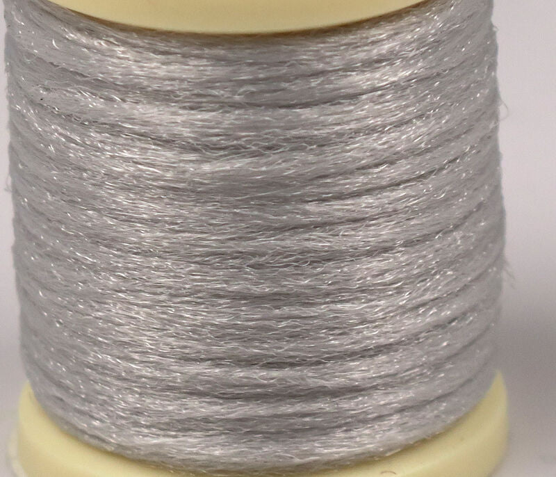 Hareline Antron yarn spool in pale silver, translucent synthetic strands with subtle sparkle, fine texture for fly tying