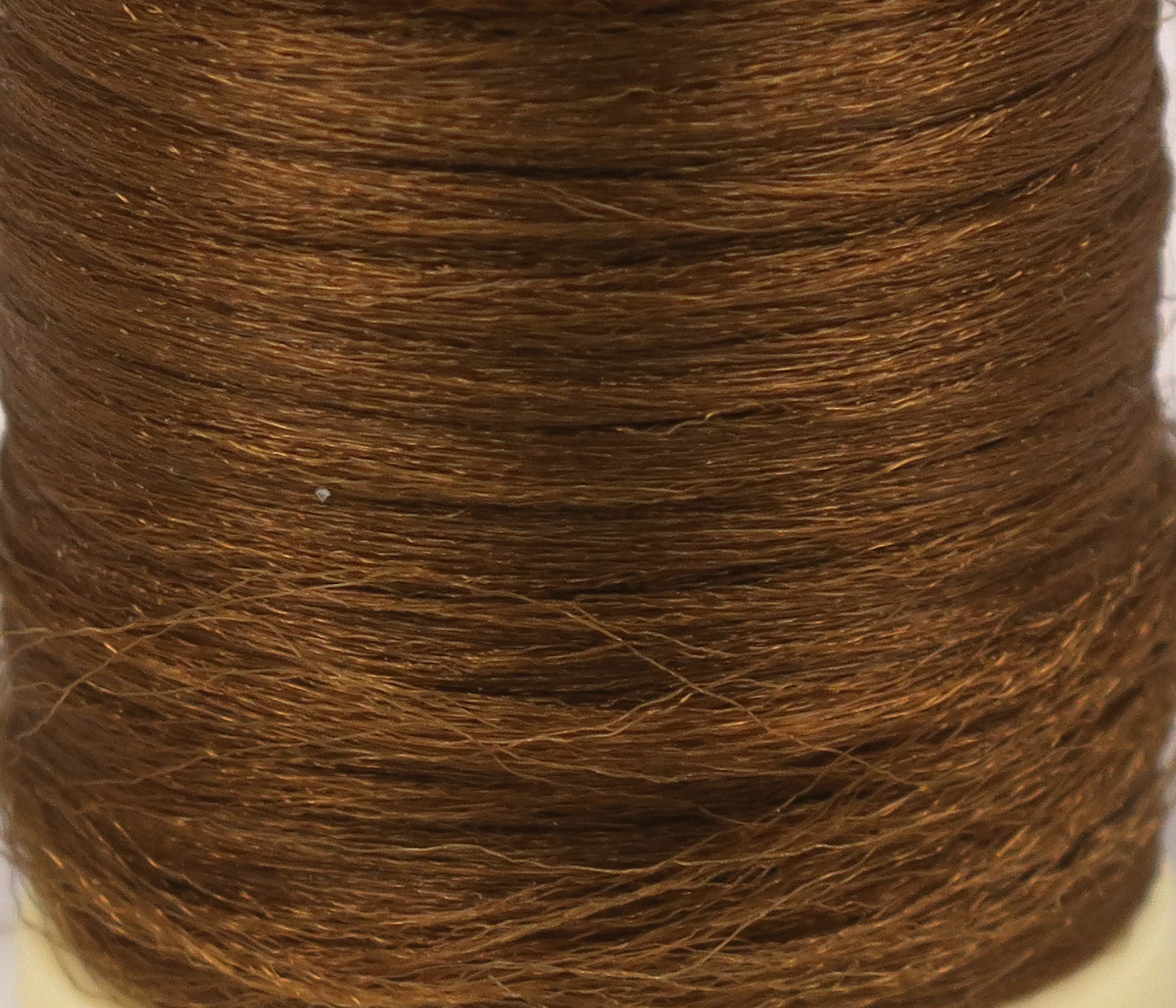 Copper brown Hareline Antron yarn spool with fine shiny synthetic fibers for fly tying