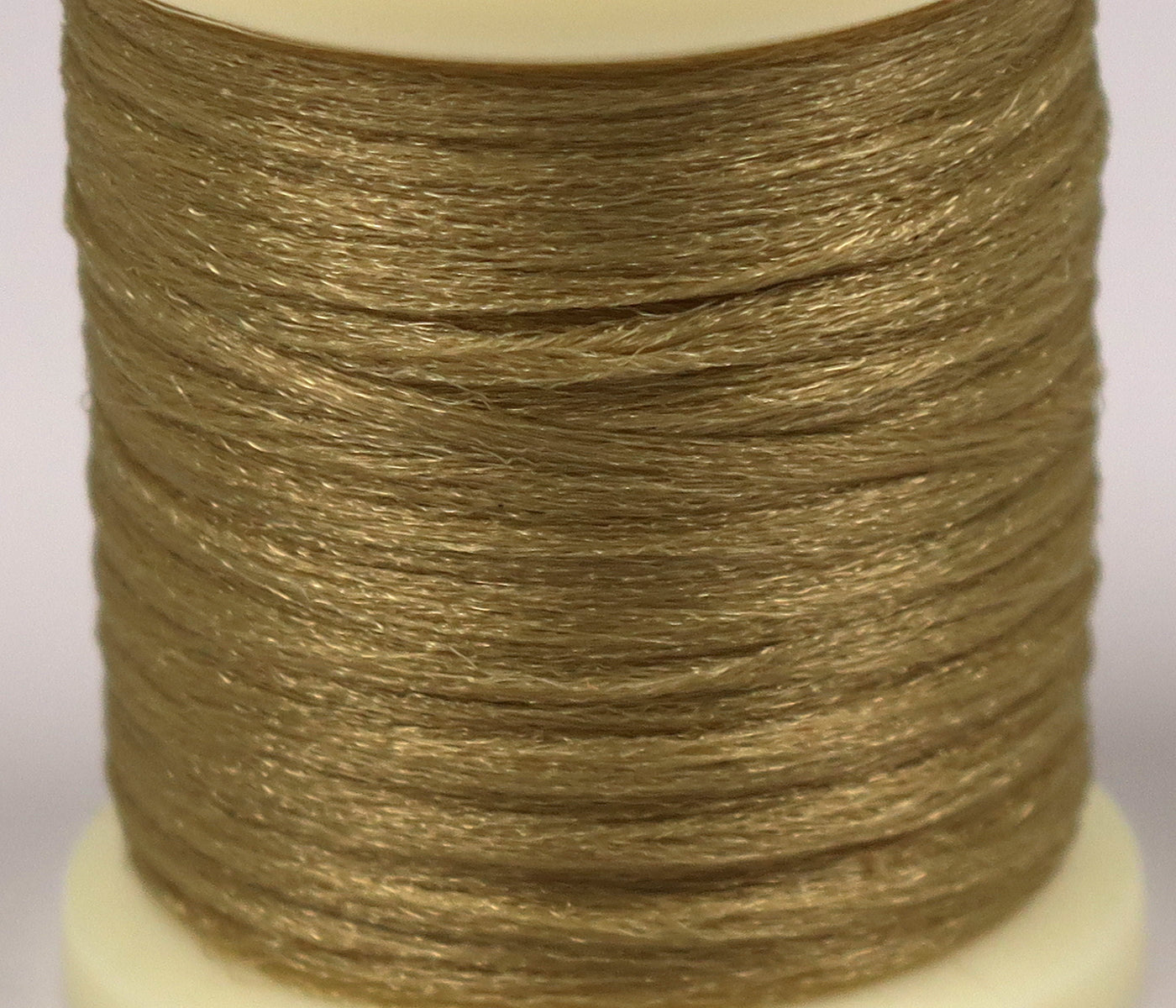 Shimmering olive-brown Hareline Antron yarn spool with fine synthetic fibers for fly tying
