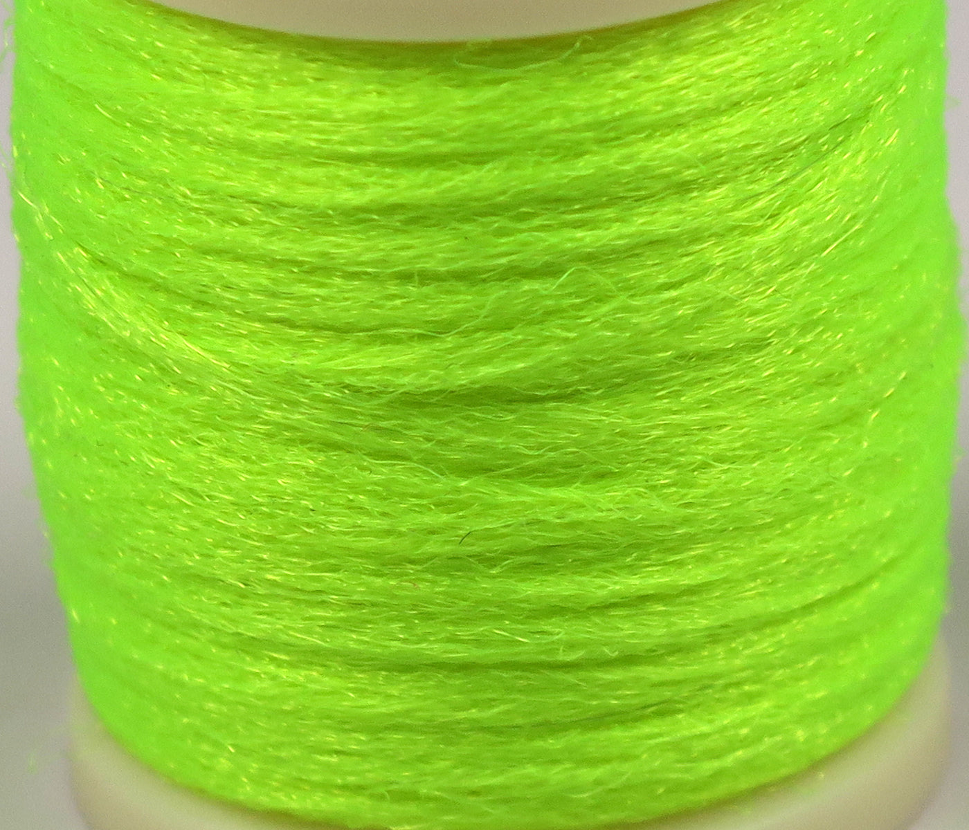Neon chartreuse Hareline Antron yarn spool with fine fuzzy synthetic fibers for fly tying