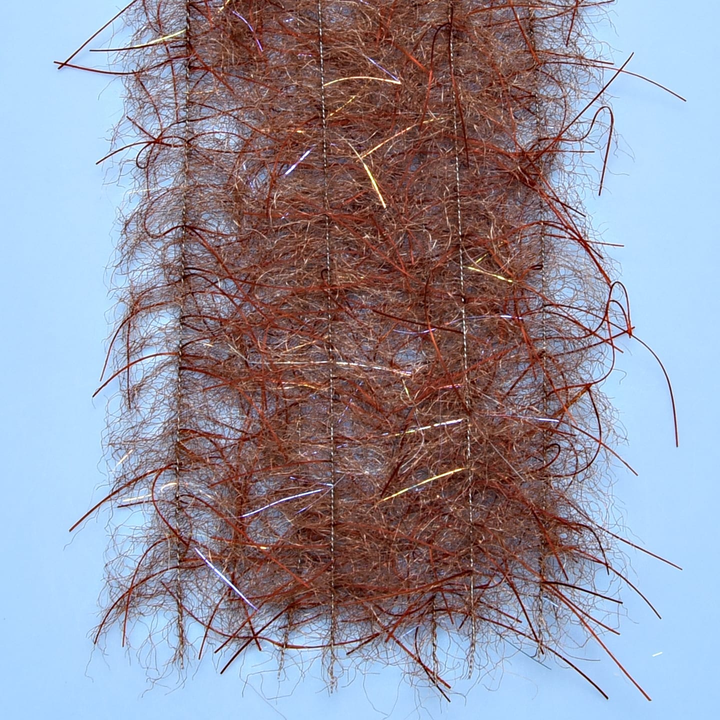 Copper-brown tarantula-style brush with hairy synthetic fibers and iridescent flash strands for fly tying