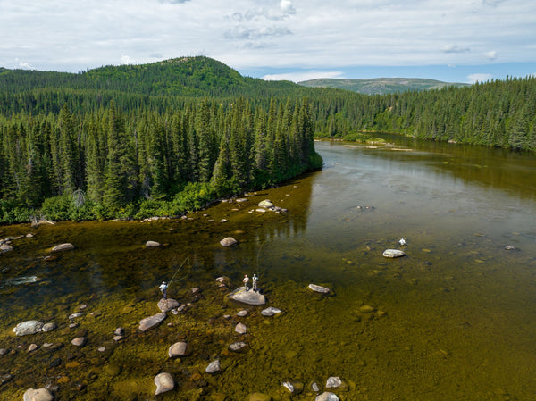 Boreal forest river landscape with anglers fishing in pristine wilderness waters near Flowers River Lodge