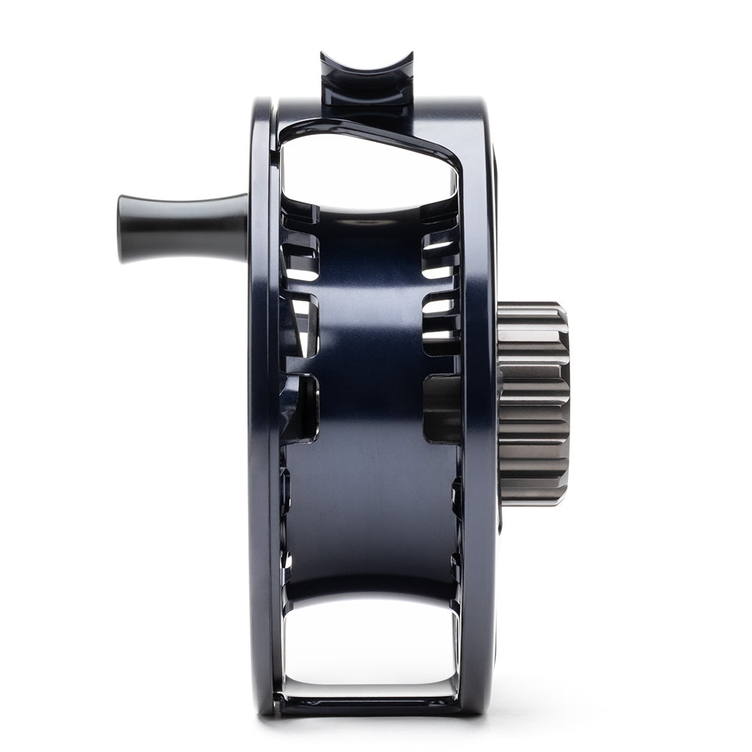 Lamson Guru X black fly reel with exposed gear system and aluminum construction, side view.