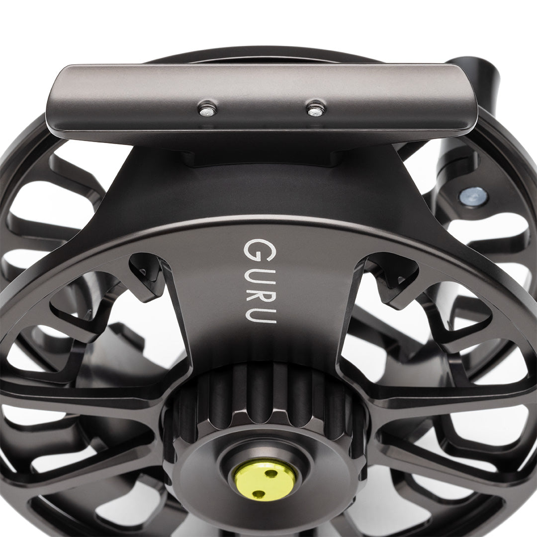 Lamson Guru X black fly reel with large arbor design and yellow indicator dot, front view