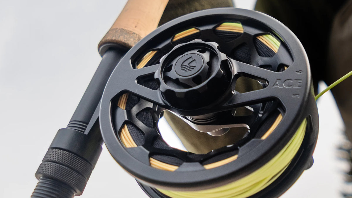 Redington Ace Tactical Edition black fly reel with gold accents and yellow line on cork handle rod