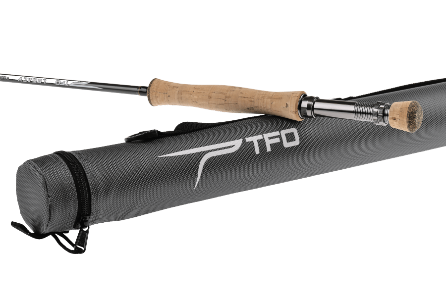TFO Legacy fly rod with cork handle and silver reel seat resting on a gray textured carrying case with TFD logo