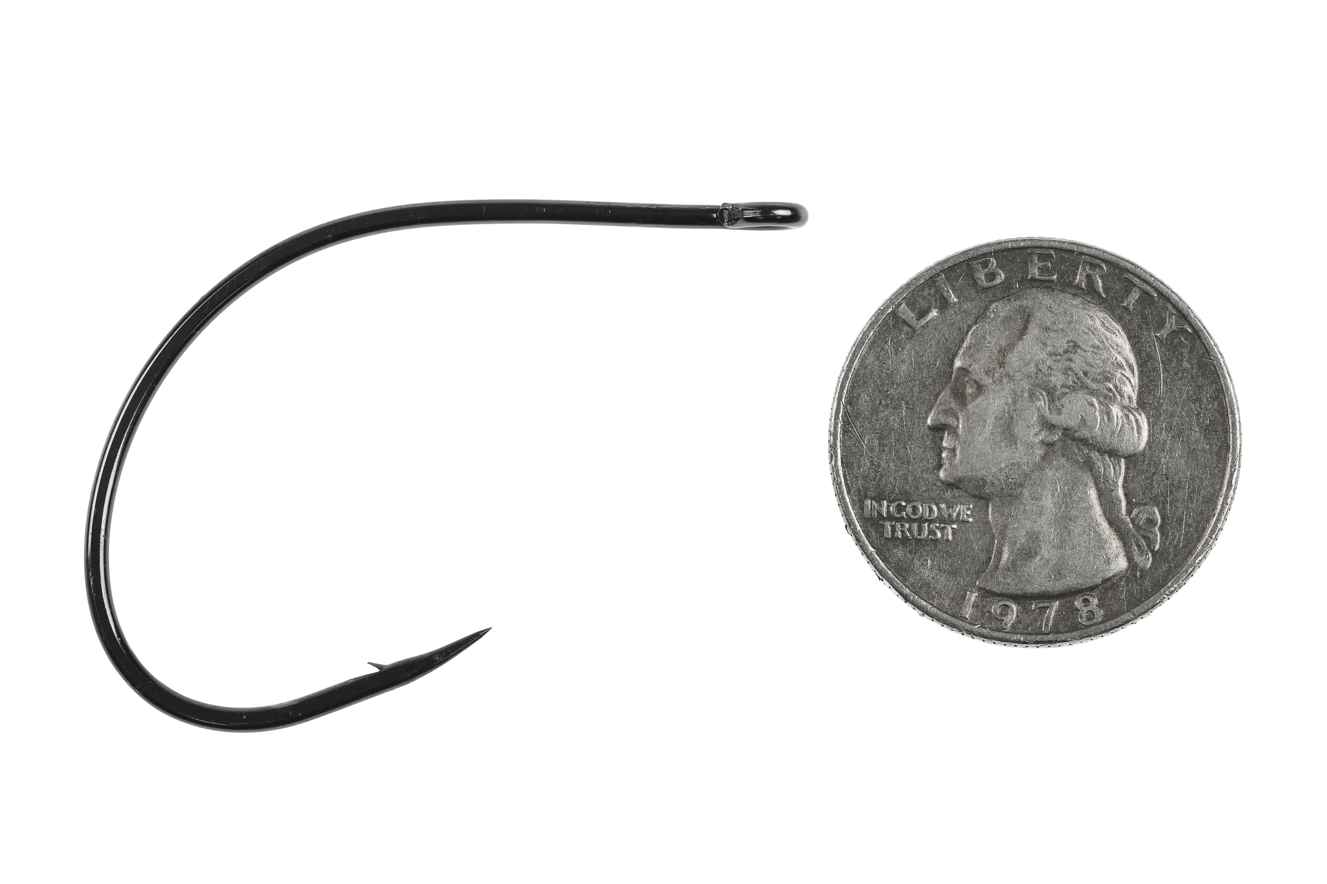 Black Ahrex AXO774 curved fly tying hook with wide curved shank and turned-up eye beside US quarter for scale
