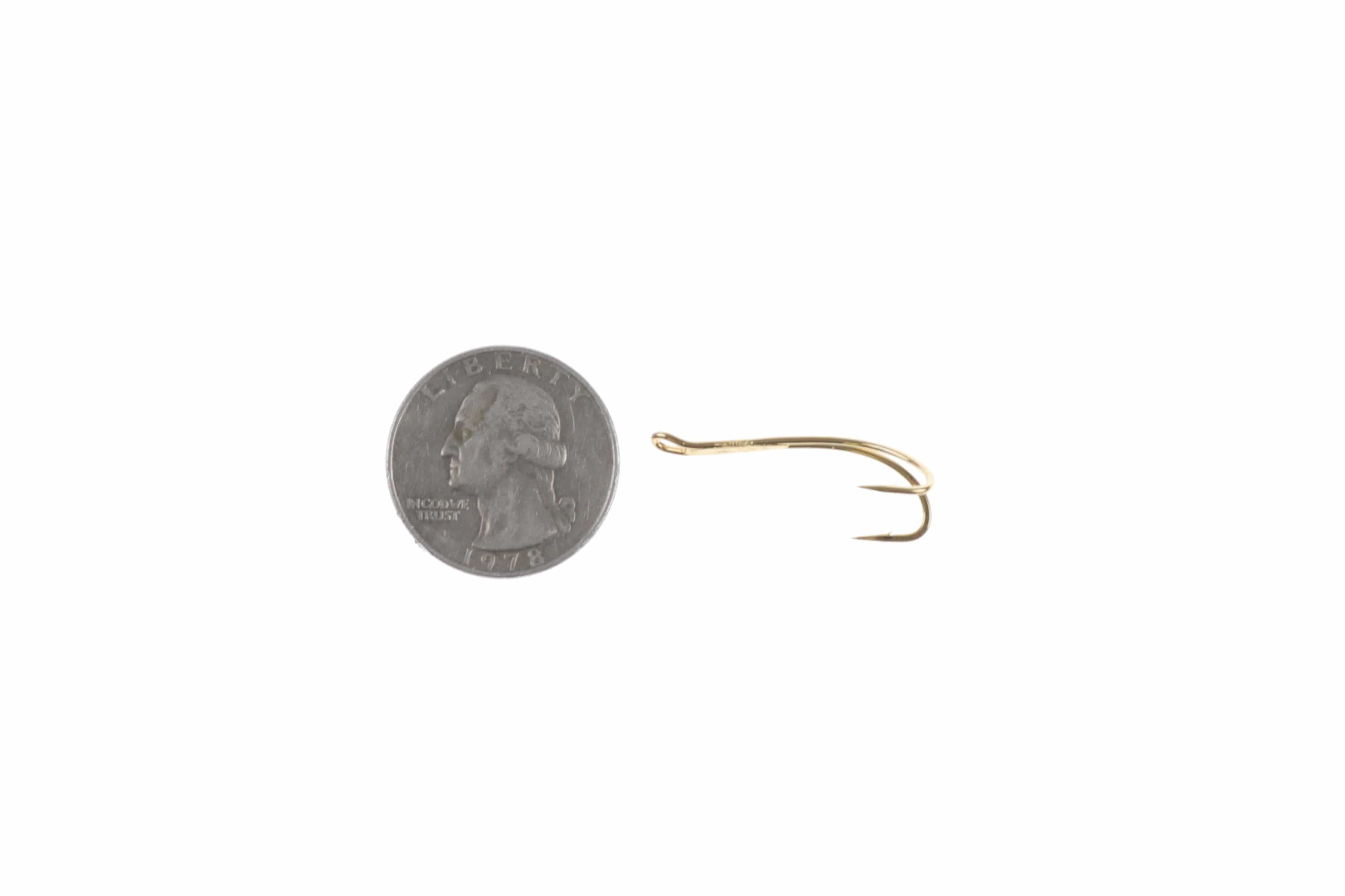 Ahrex gold progressive double hook with twin barbs, shiny metal fly tying hook shown beside US quarter for scale