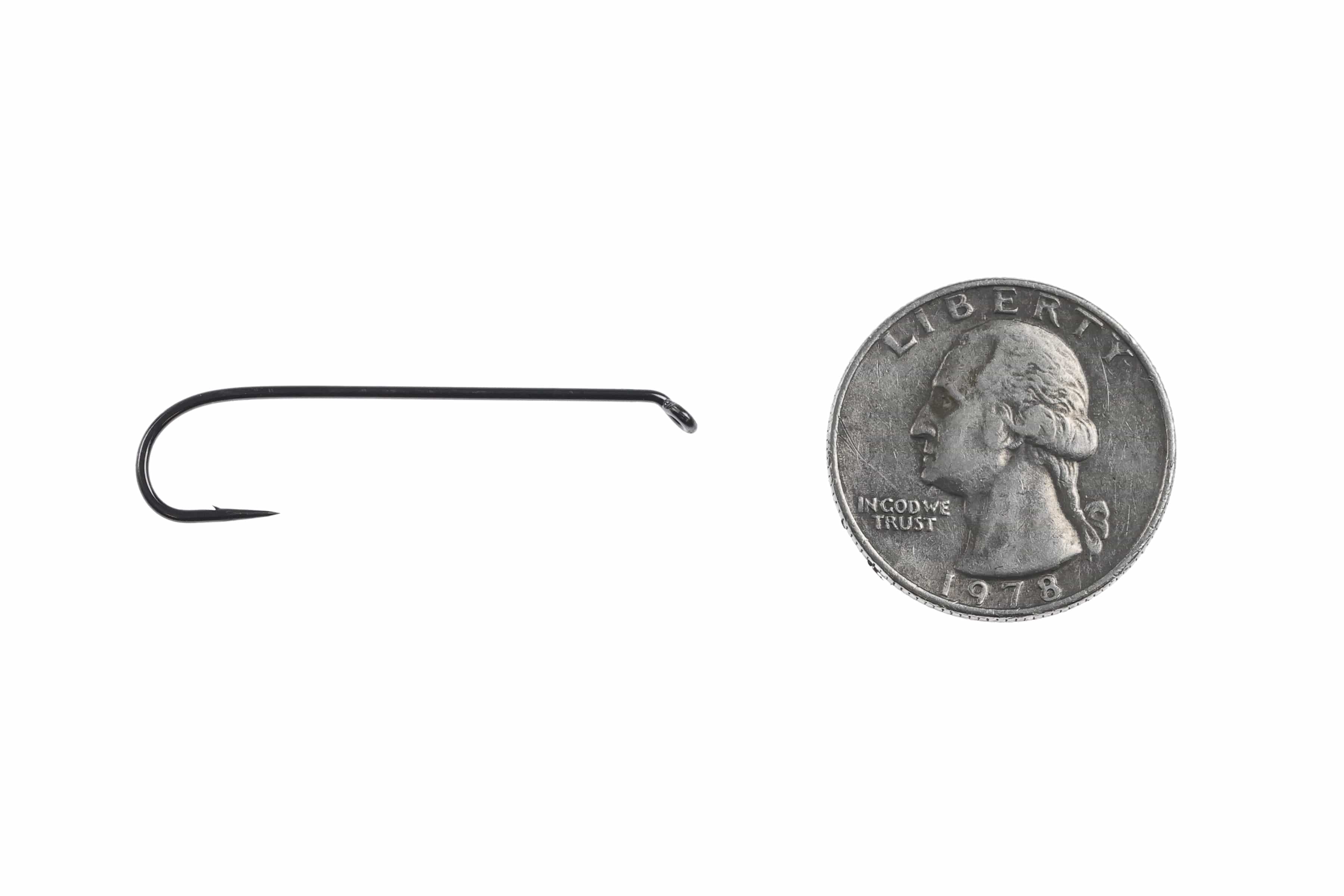 Ahrex NS118 black nickel streamer hook, long shank wide-gape saltwater fly tying hook beside quarter for scale
