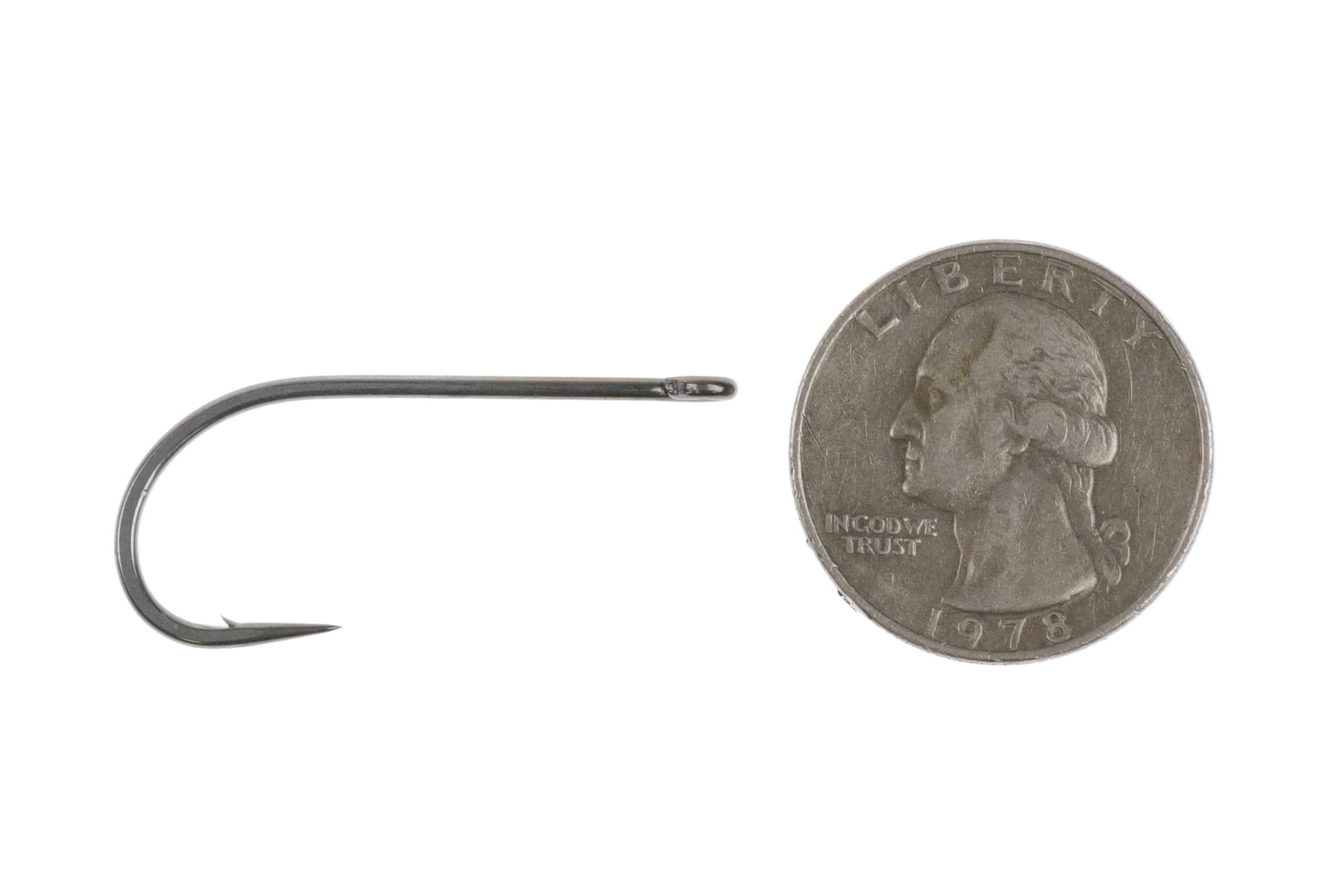 Ahrex SA210 fly tying hook in gunmetal finish, wide-gap steel hook with straight eye shown beside US quarter for scale
