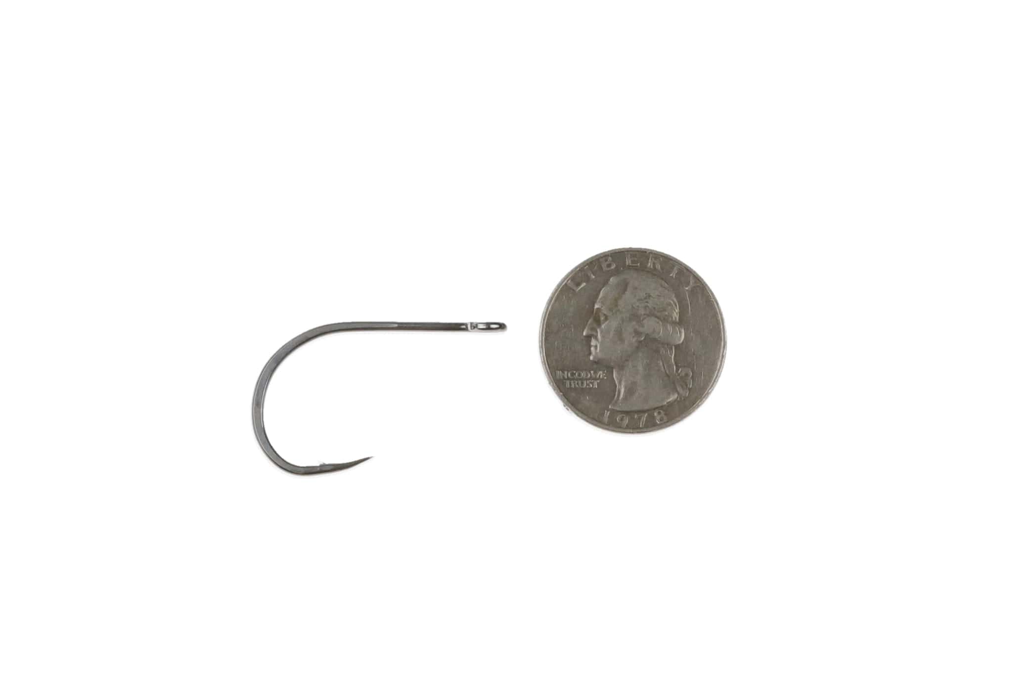 Ahrex saltwater minnow hook in gunmetal finish with round bend and sharp point beside US quarter for scale