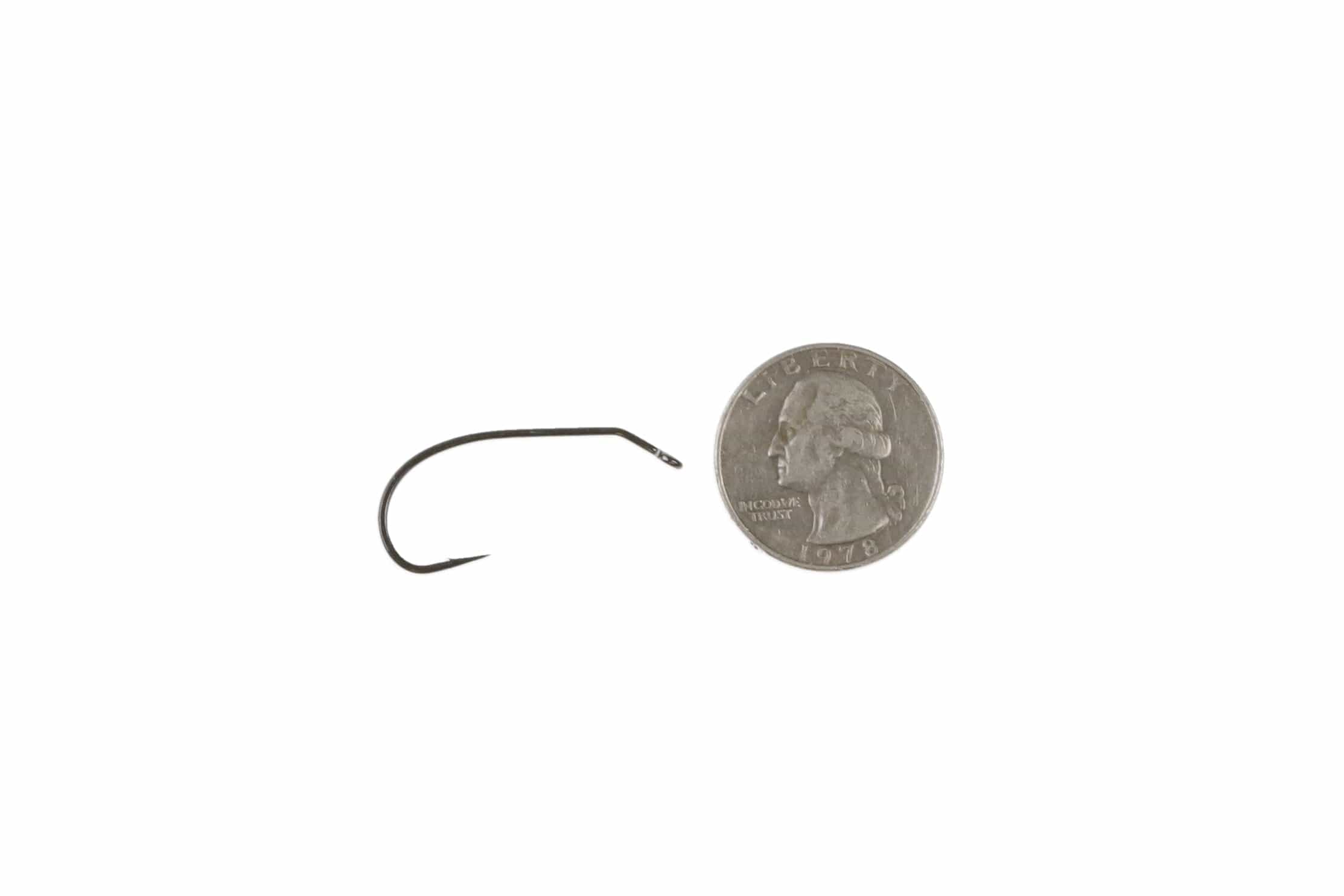 Ahrex matte black bent streamer hook with up-eye and wide bend beside US quarter for scale, fly tying hook