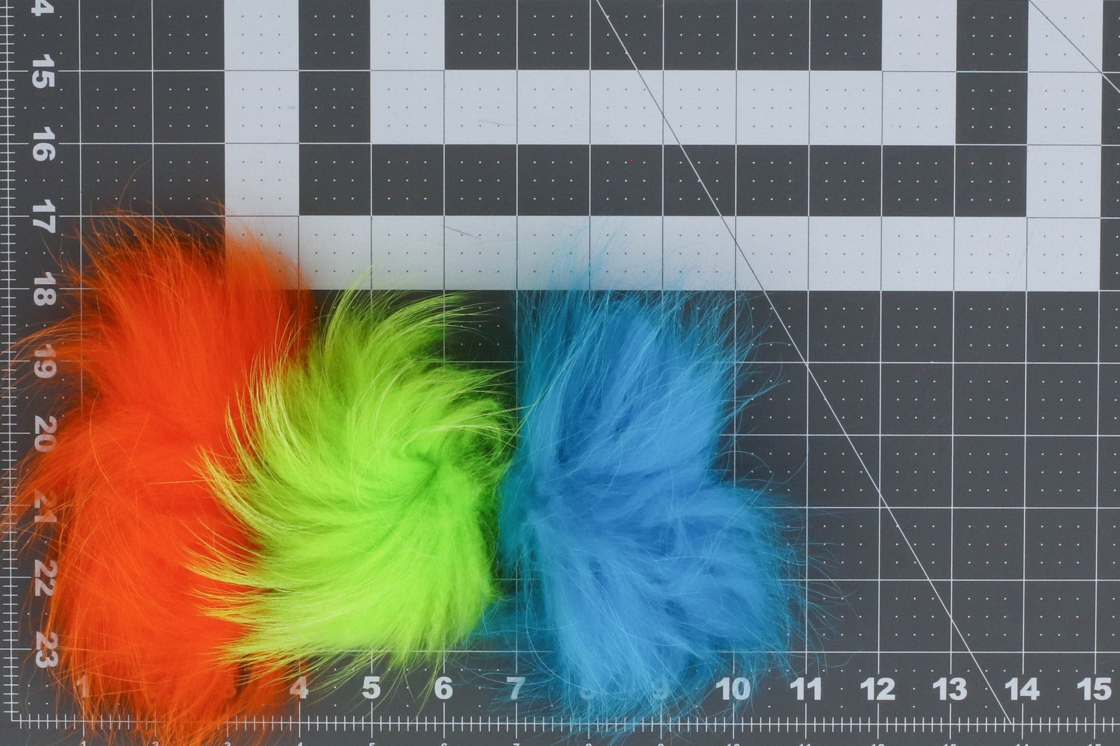 Arctic Fisherman Finn raccoon fur clumps in bright orange, chartreuse green and sky blue for fly tying