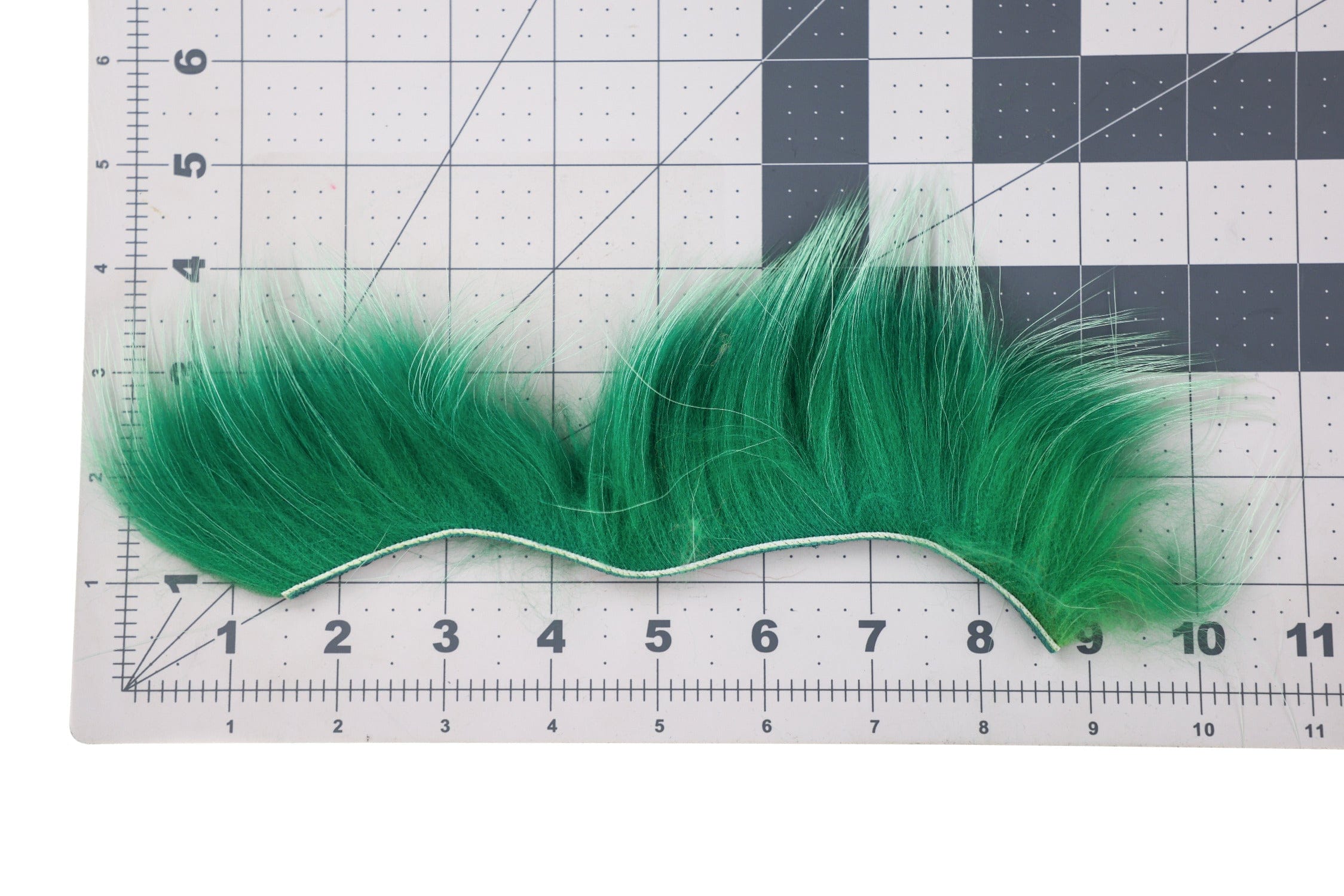 Vibrant green raccoon fur zonker strip for fly tying, long soft fibers on white leather backing
