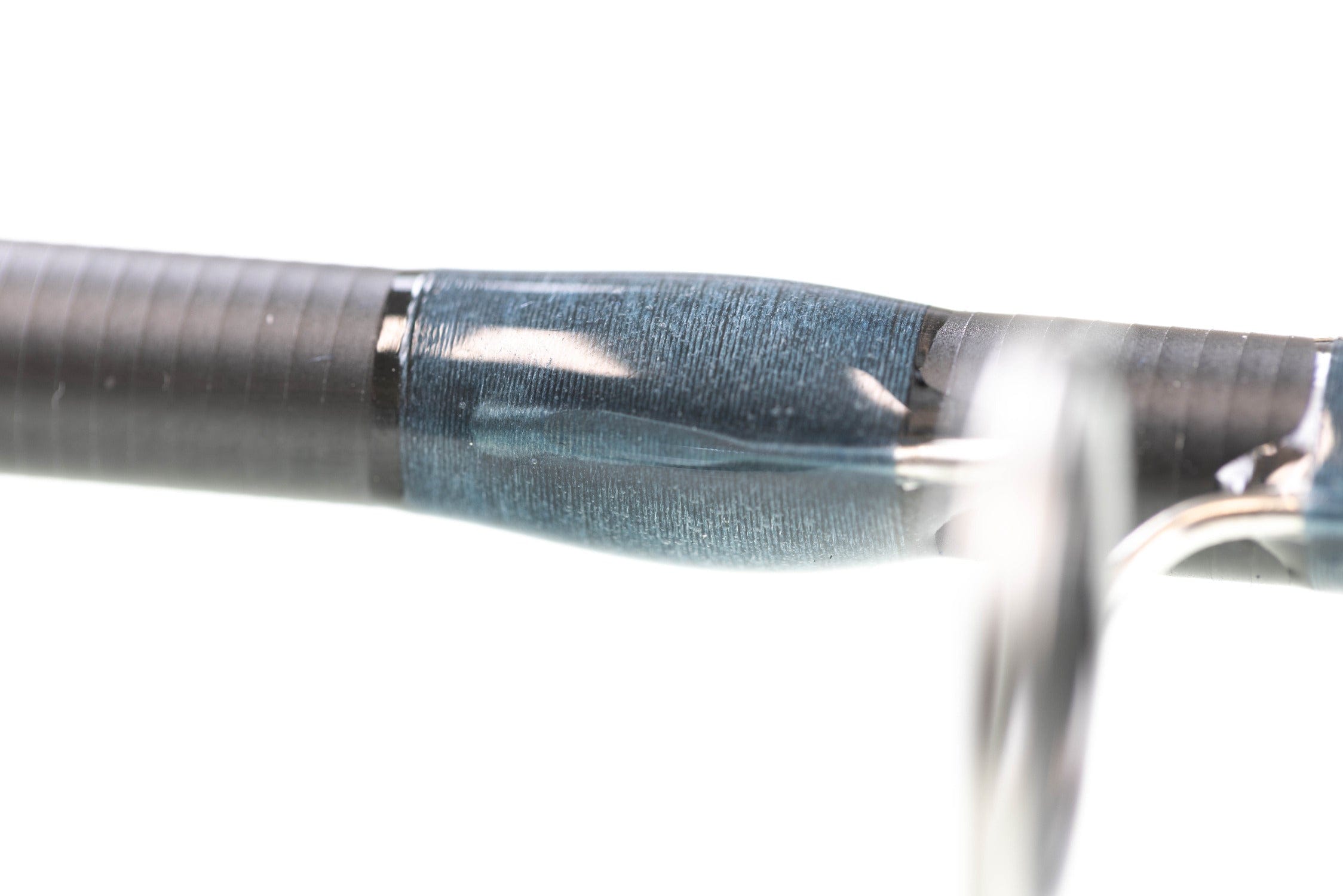 Atlas 9ft 8wt fly rod close-up showing blue silk thread wrap with glossy epoxy over black carbon blank and stainless guide.