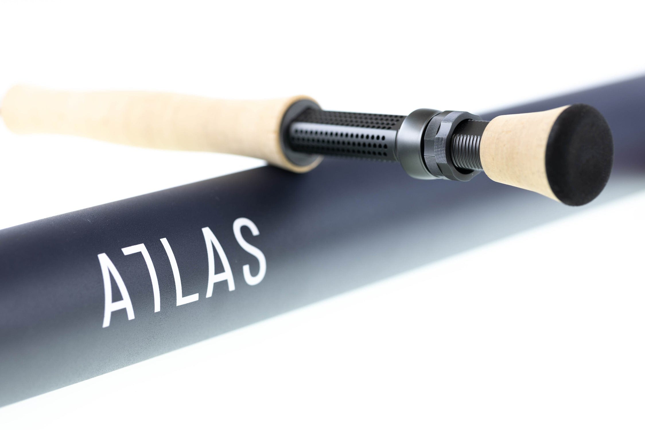 Atlas Signature 9ft 8wt fly rod with cork grip and black perforated reel seat resting on matte navy tube with ATLAS logo