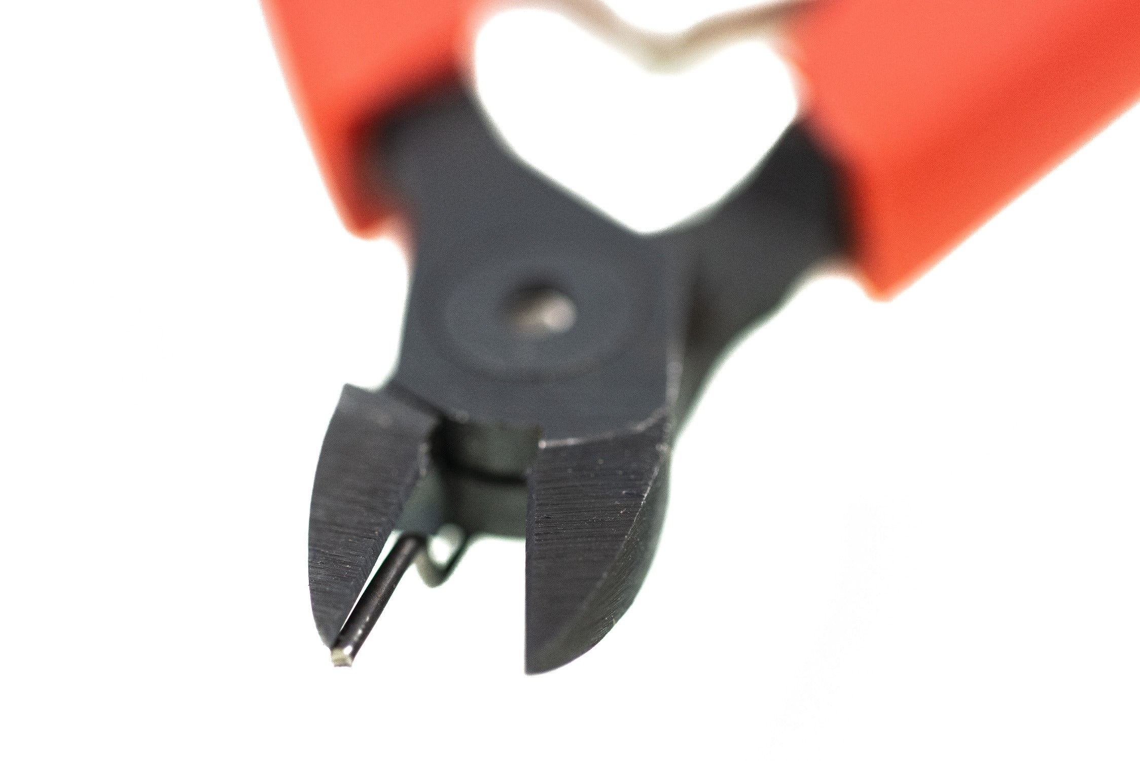 Black steel flush cutter pliers with orange rubber handles and integrated wire catcher for fly tying