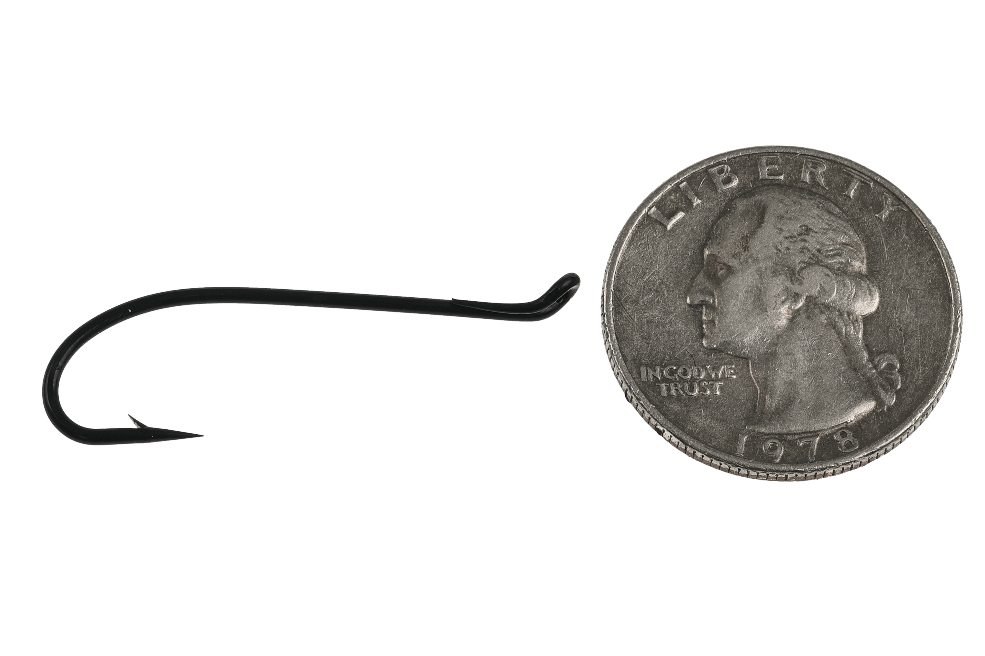 Matte black steel fly-tying hook with curved shank, short barb and turned-up eye beside a US quarter for scale