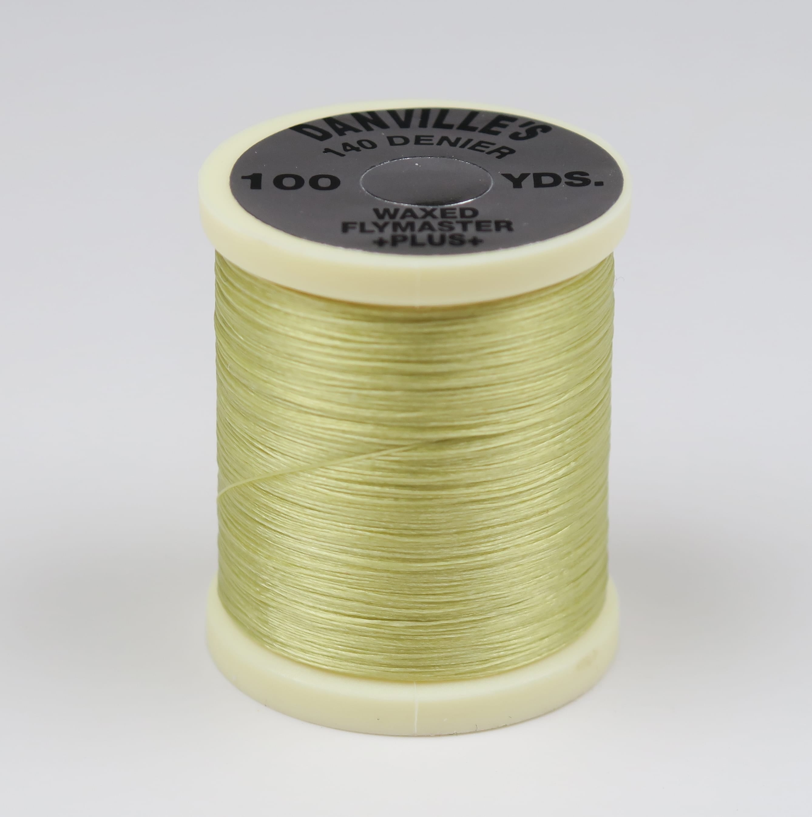 Pale chartreuse waxed fly tying thread wound on cream Danville spool labeled 140 denier 100 yds