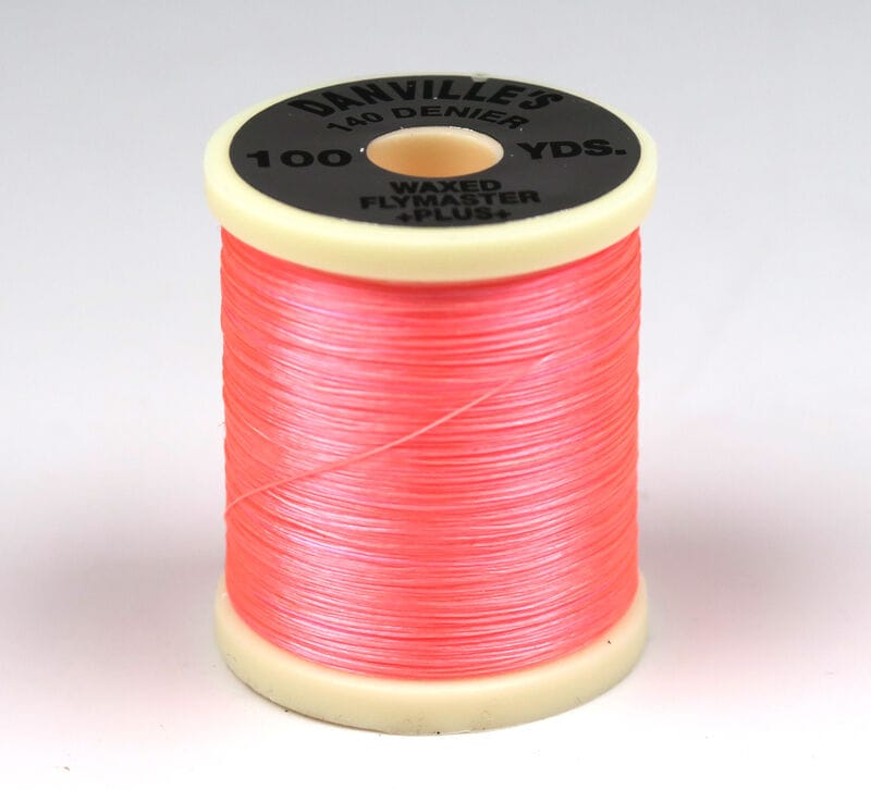 Coral-pink waxed Danville Flymaster Plus 140 denier nylon fly-tying thread spool with cream plastic ends