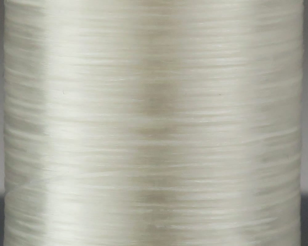 Close-up spool of Danville flat waxed thread in translucent cream with glossy flat 210-denier layers for fly tying