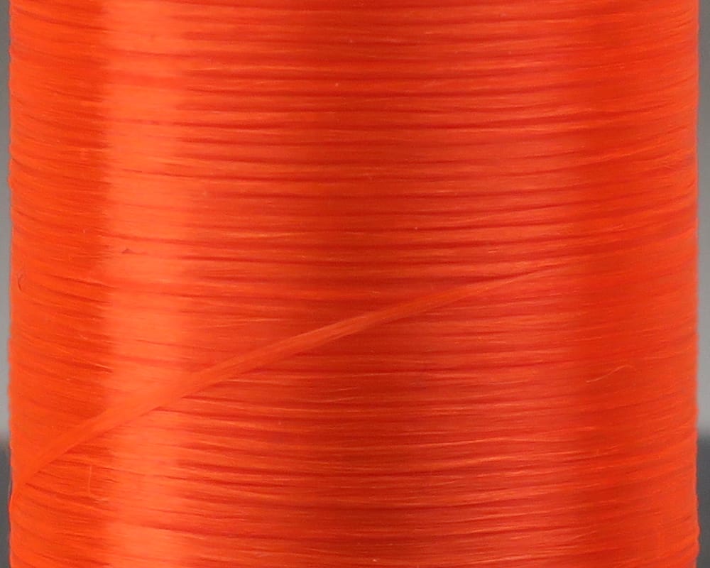Bright orange flat waxed fly tying thread spool with smooth glossy strands