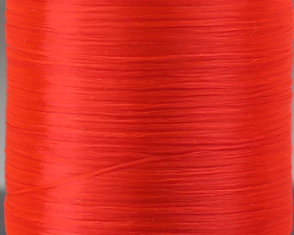 Bright red Danville 210 denier flat waxed thread spool close-up showing smooth waxed texture for fly tying