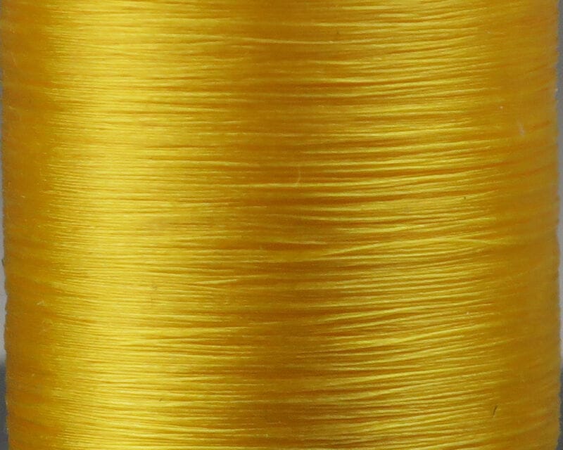 Bright golden yellow Danville Flymaster 6/0 70 denier glossy synthetic fly tying thread spool, smooth lustrous strands