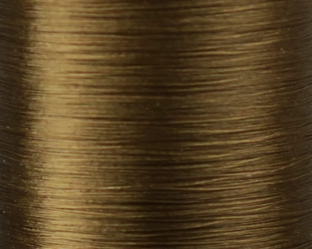 Danville Flymaster 6/0 golden-brown 70 denier polyester fly tying thread spool close-up showing fine smooth wound strands