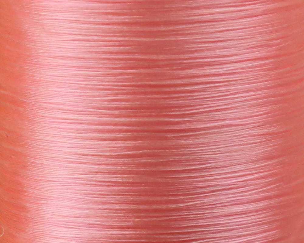 Danville Flymaster 6/0 (70 denier) glossy coral-pink synthetic fly tying thread tightly wrapped on spool