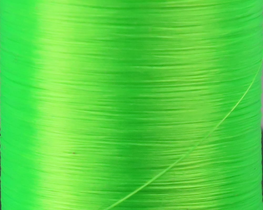 Fluorescent chartreuse Danville Flymaster fly tying thread spool close-up, smooth nylon sheen, 6/0 70 denier