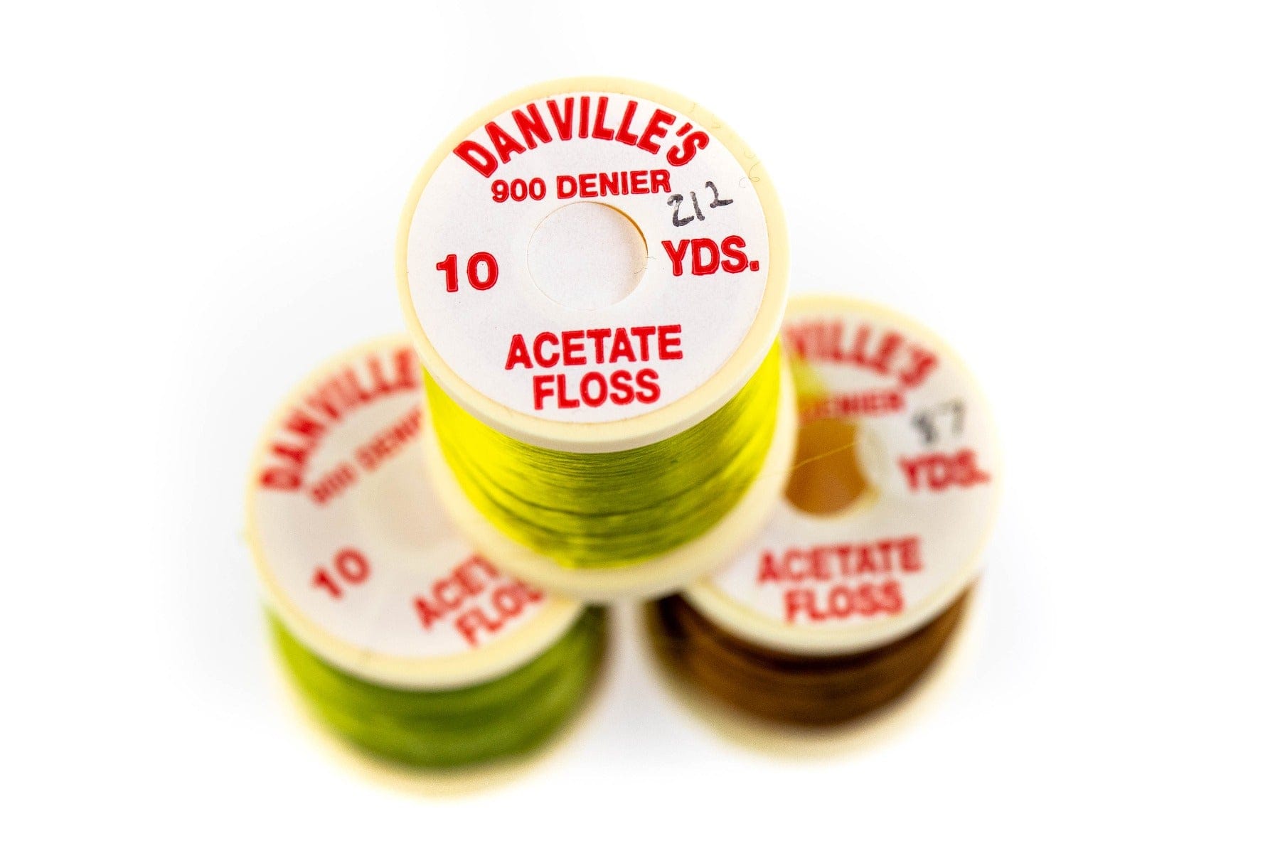 Stacked Danville acetate floss spools in bright chartreuse and brown, smooth shiny filament thread for fly tying