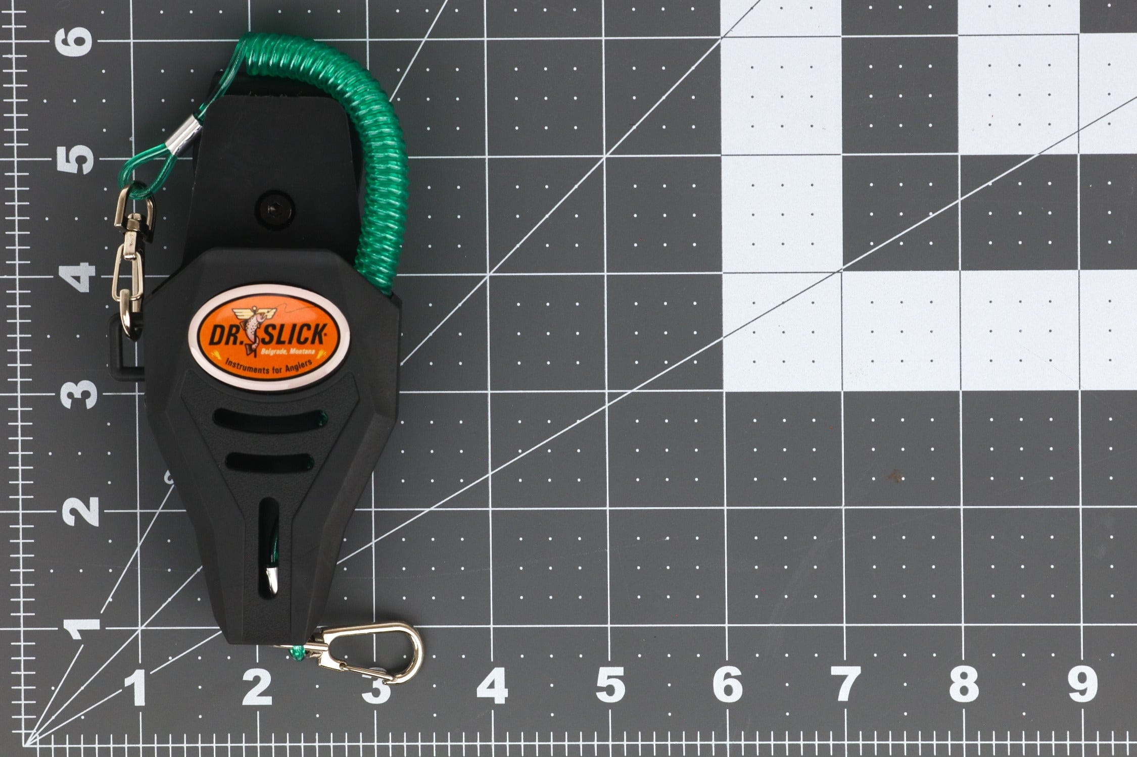 Black molded Dr. Slick 5in holster with orange logo, green coiled lanyard and silver carabiner clip — fishing accessory