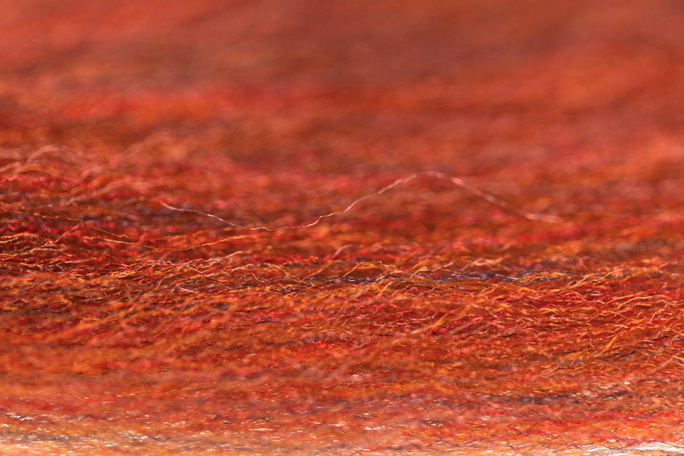 Macro close-up of Enrico Puglisi 3D silky fibers in orange-red iridescent strands for fly tying