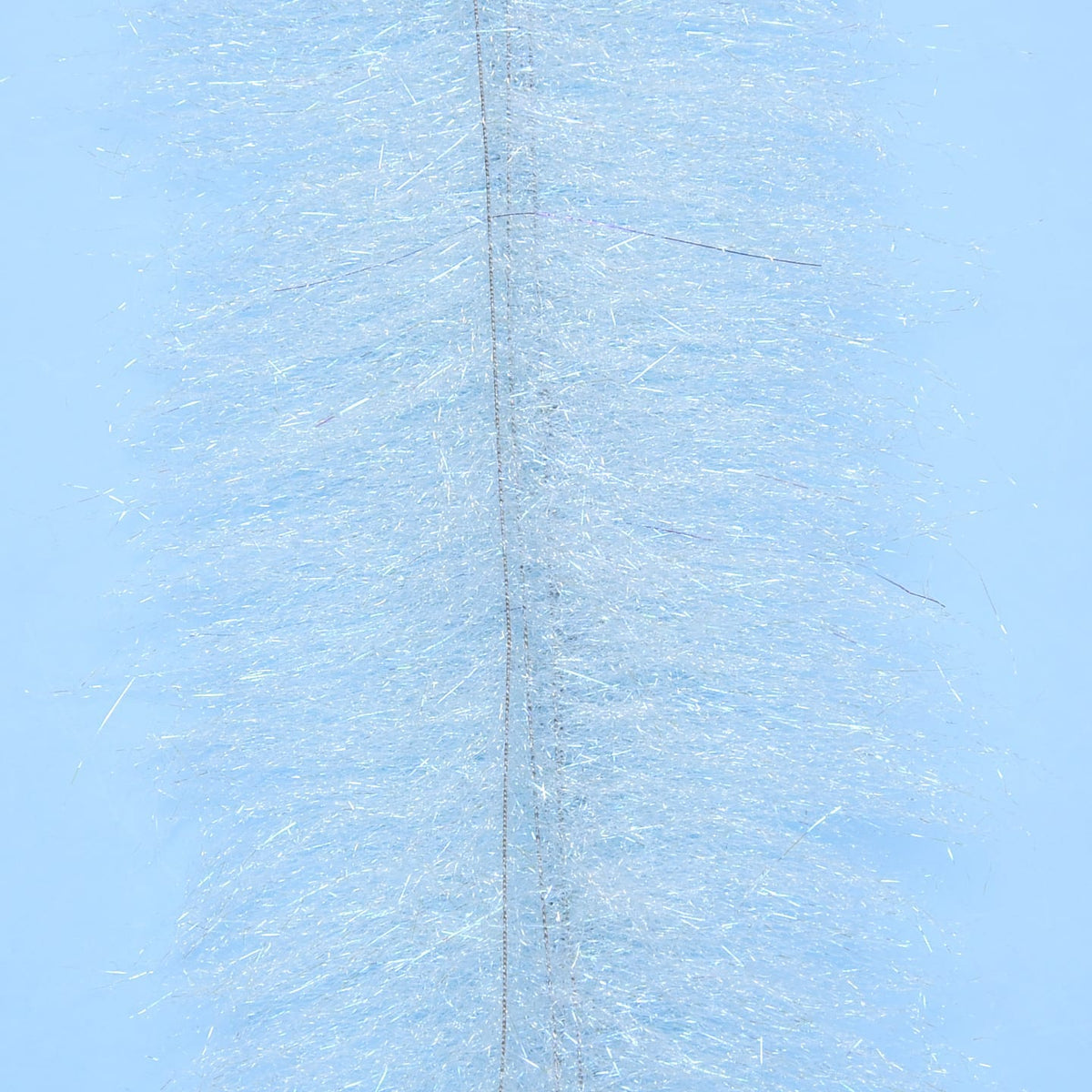 Pale blue fly tying brush with dense iridescent synthetic fibers and a visible stitched center