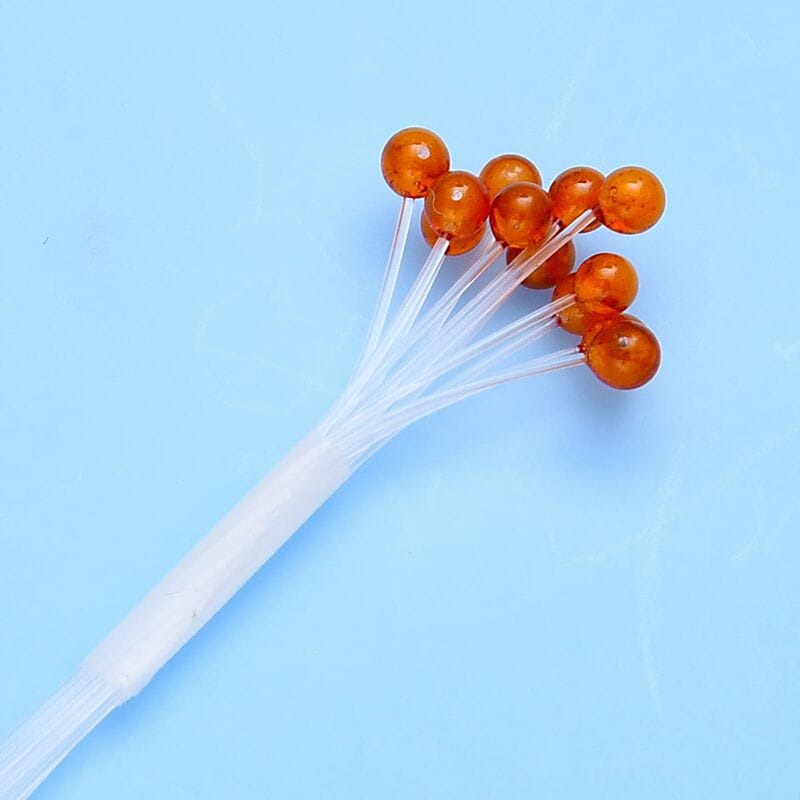 Amber translucent crab & shrimp fly tying eyes on clear stems, glossy resin beads fanned on light blue background