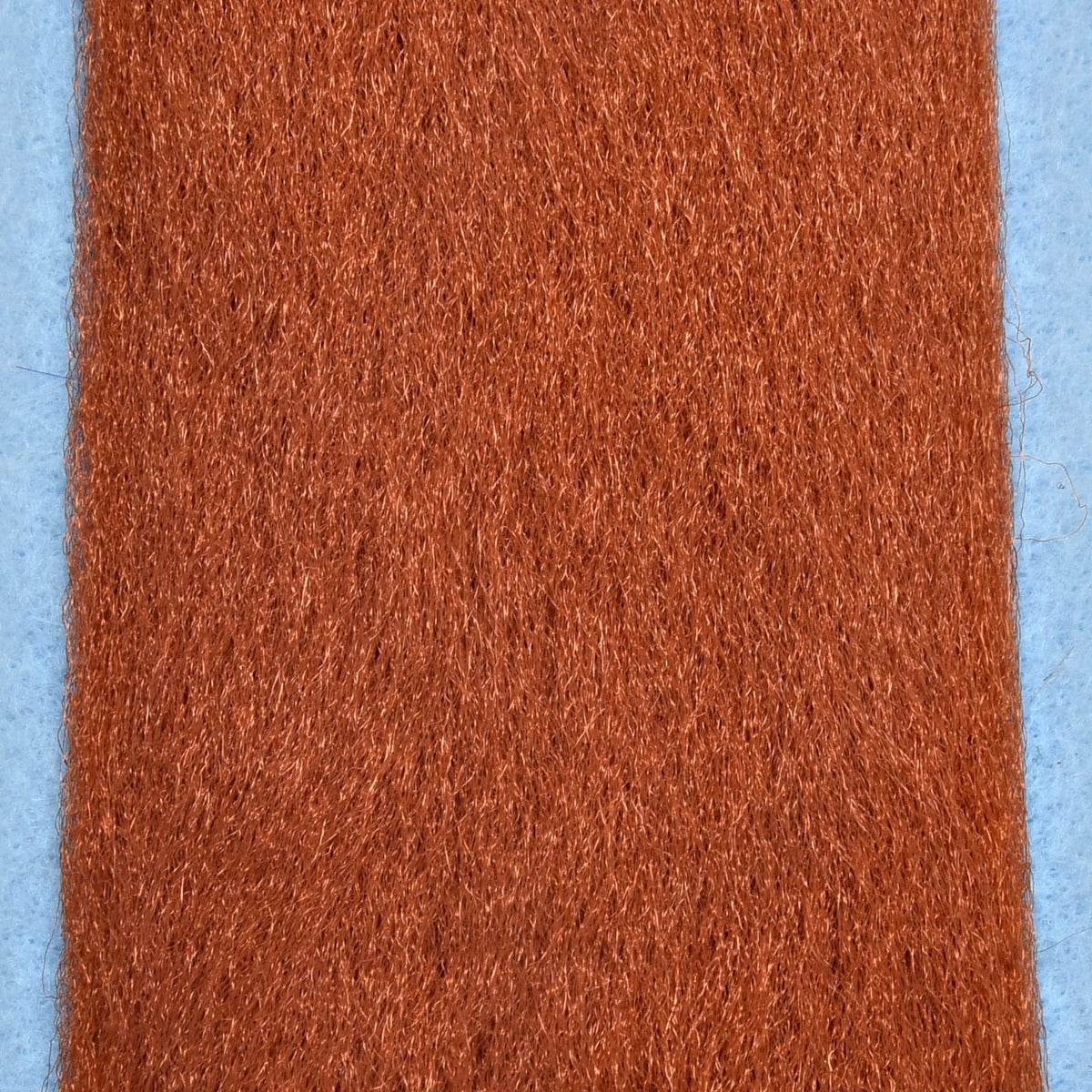 Copper-brown Enrico Puglisi EP Fibers: dense, fine synthetic fly-tying strands with subtle sheen on light blue backing