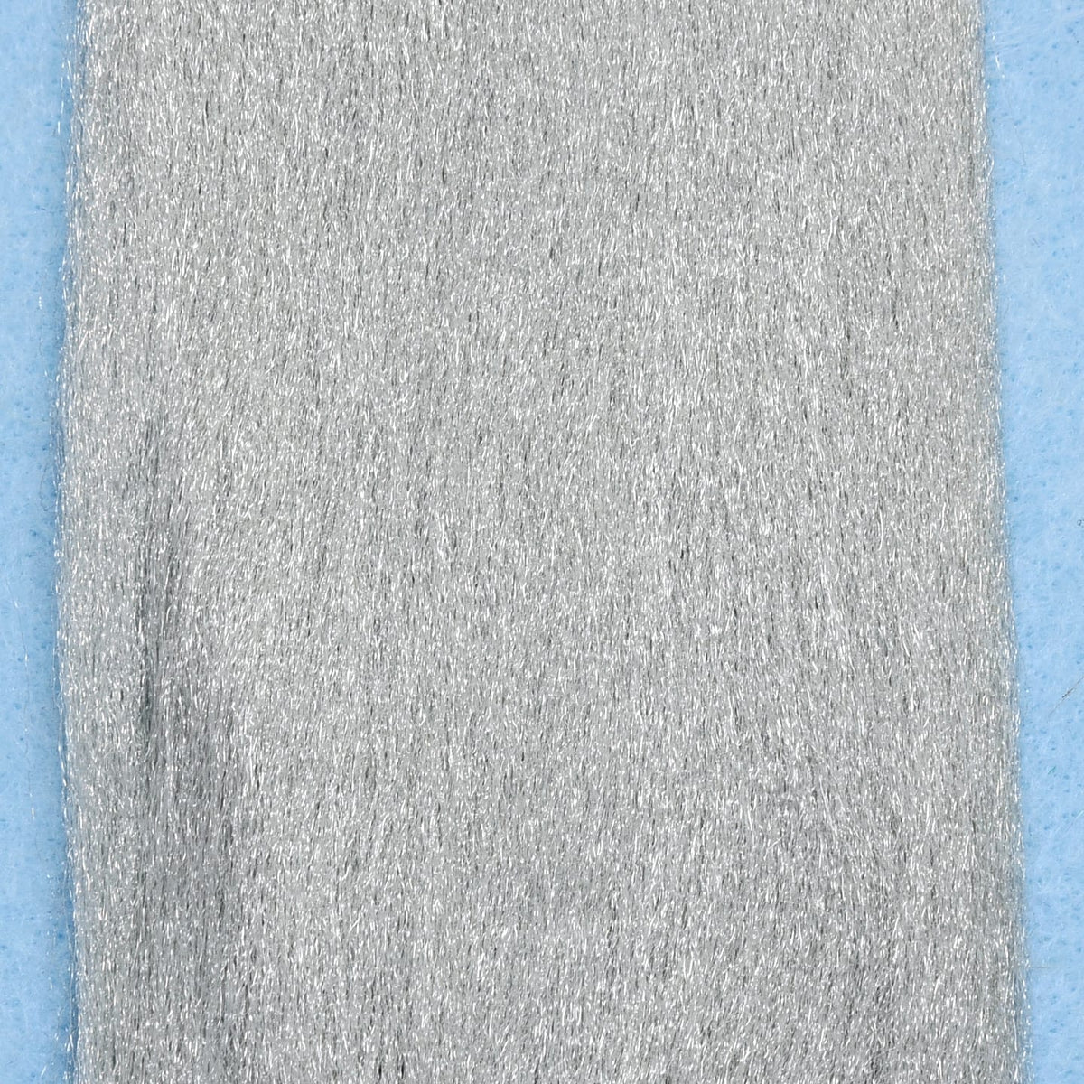 Silver metallic Enrico Puglisi EP Fibers for fly tying, dense synthetic strands on blue backing