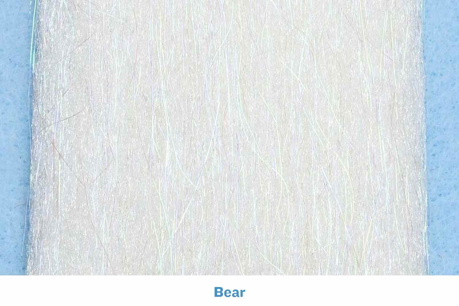 White iridescent Sculpt-A-Fly synthetic fibers bundle for fly tying, fine translucent strands on pale blue backing