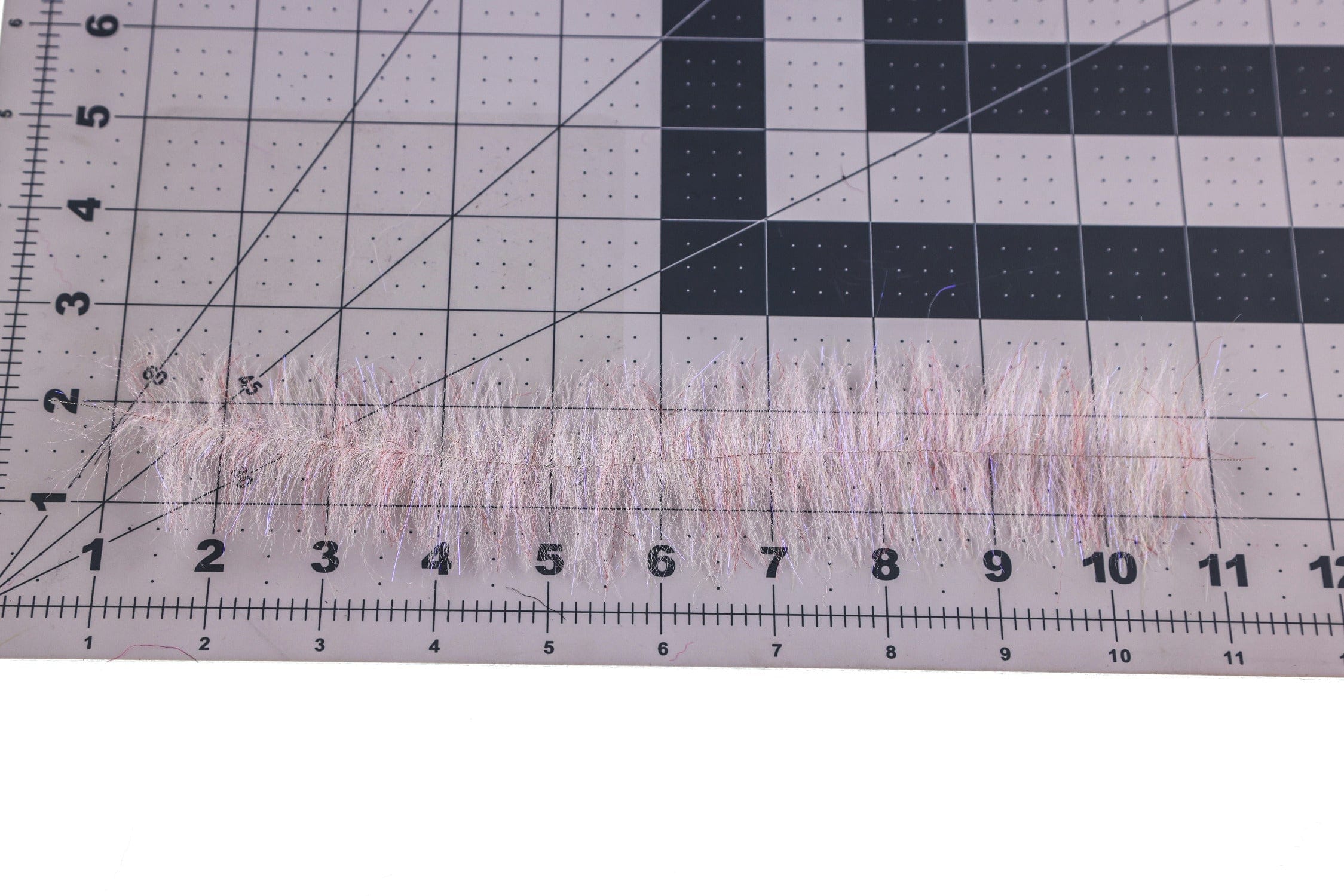 Enrico Puglisi Shrimp Dub Brush pale pink pearlescent synthetic fiber strip on cutting mat ruler for fly tying
